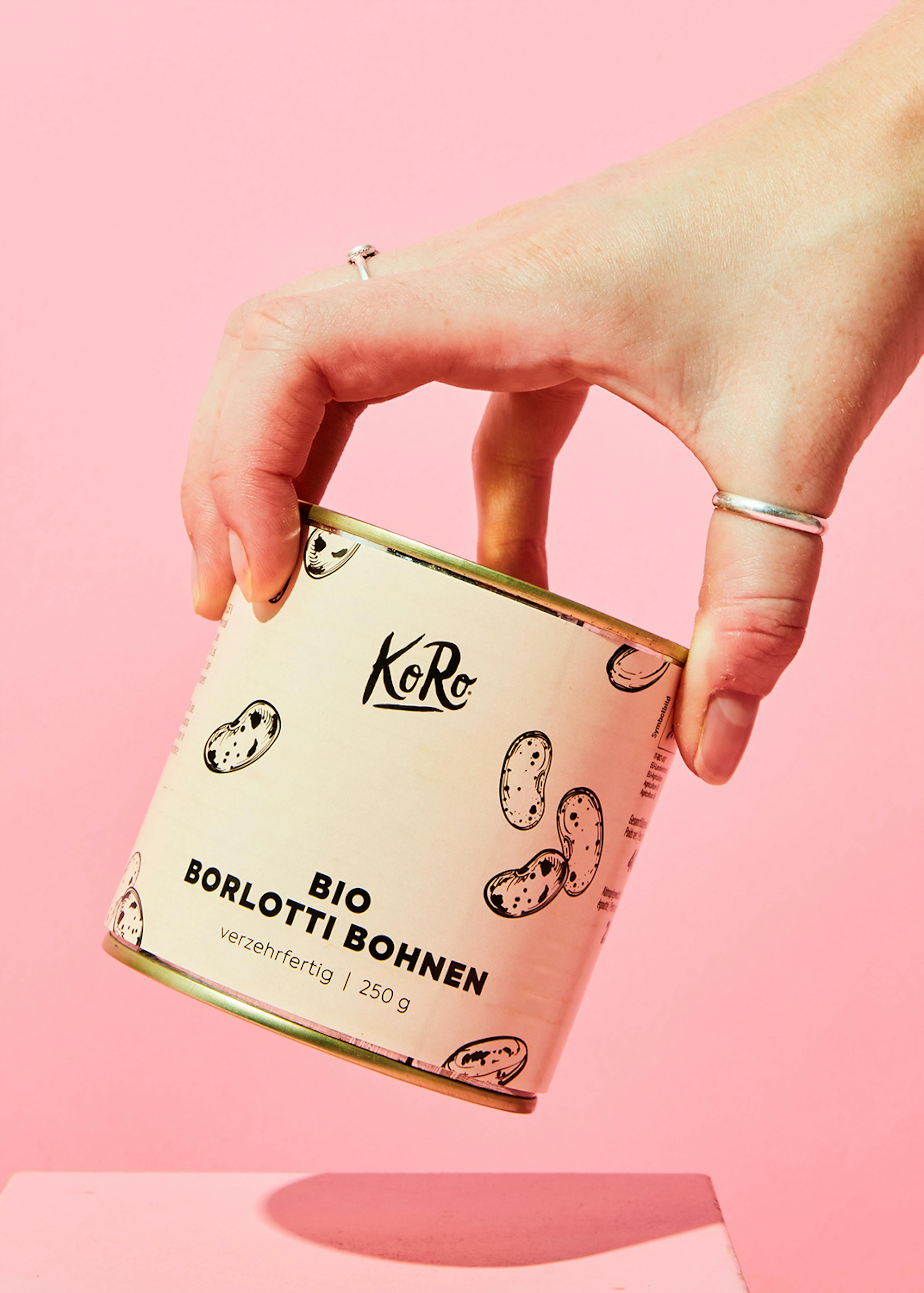 eine hand hält eine dose bio borlotti bohnen