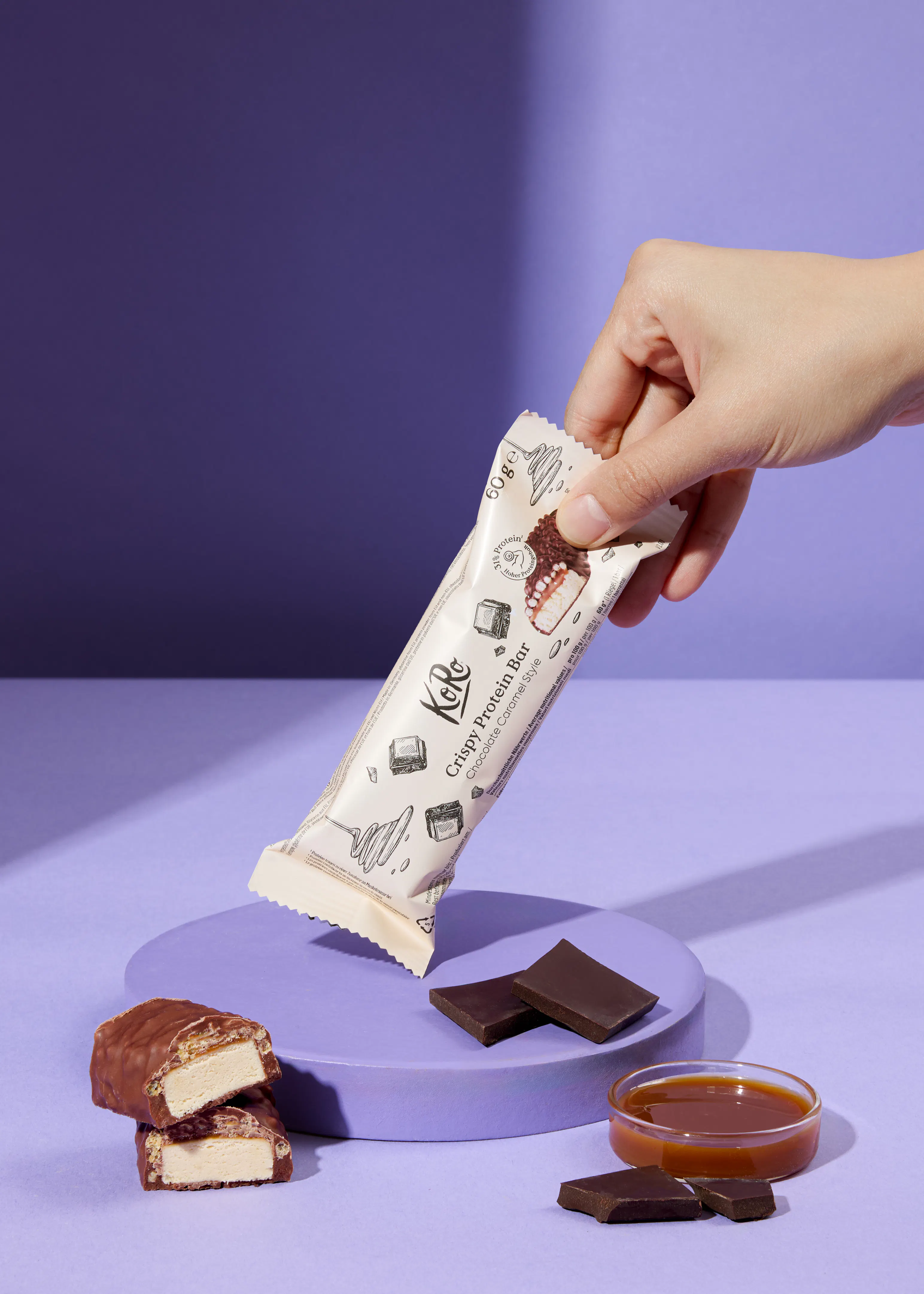 une personne tient une barre de proteine croustillante