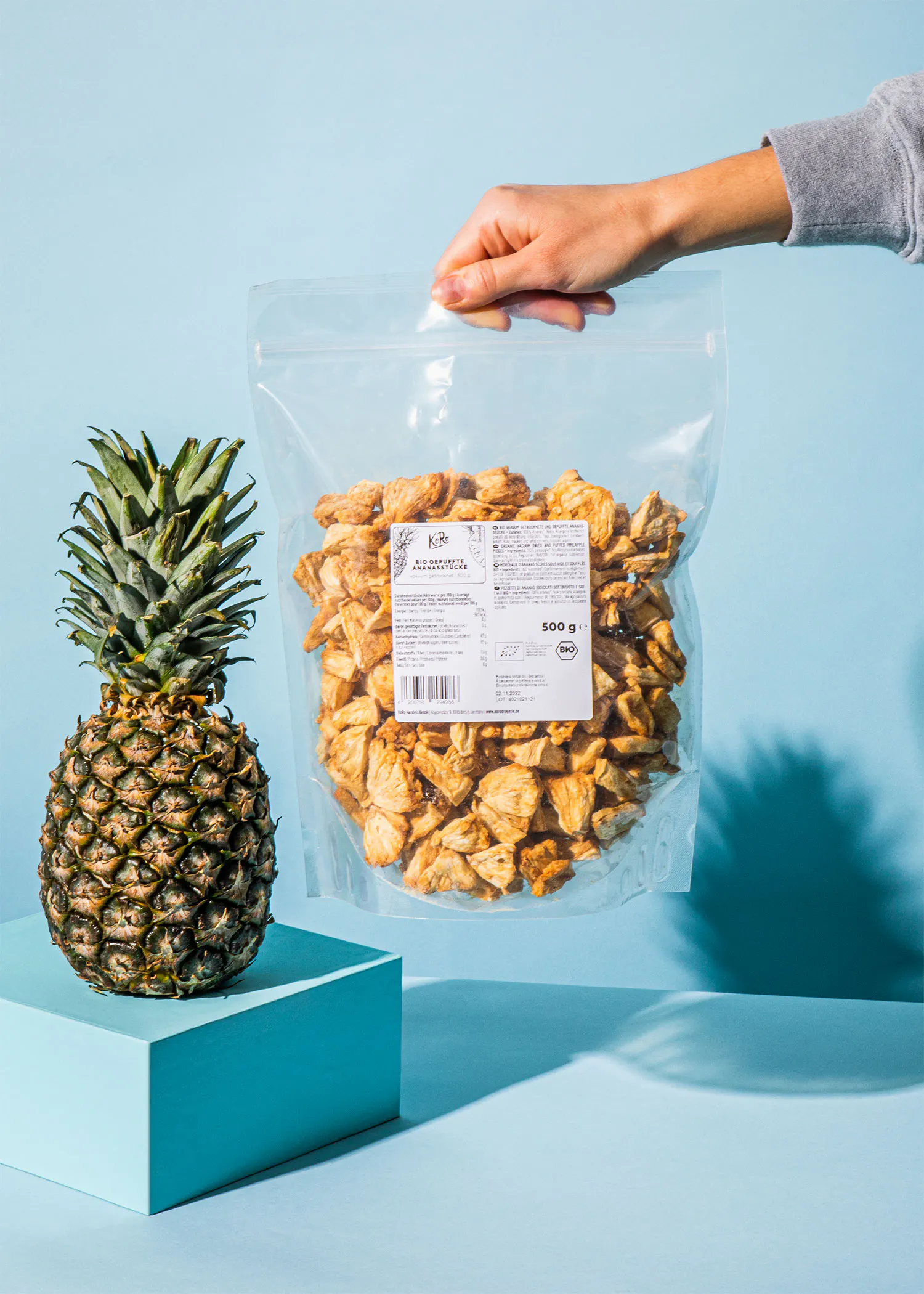 une personne tient un sac de nourriture à côté d' un ananas