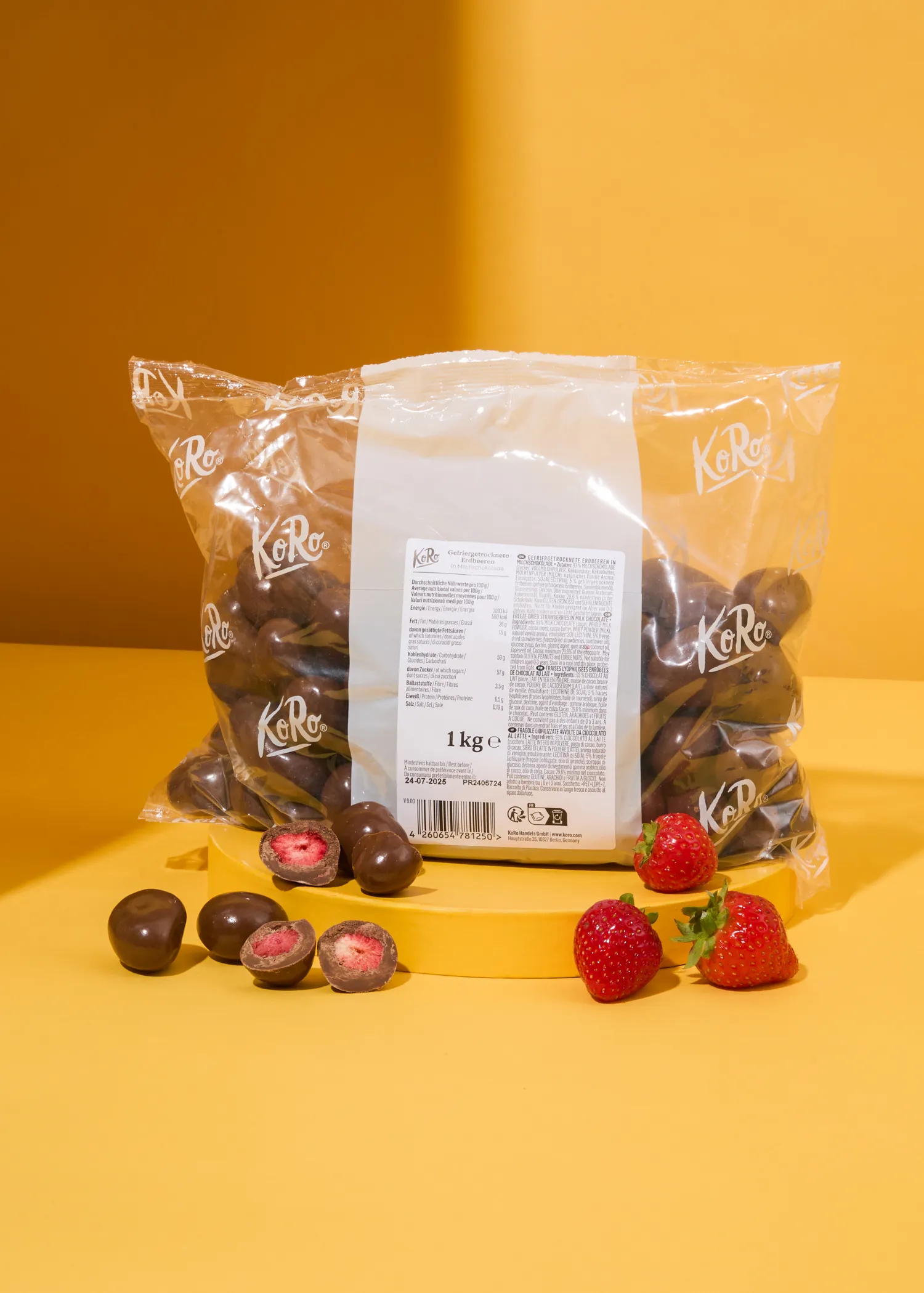 un sac de fraises enrobées de chocolat est assis sur une table jaune