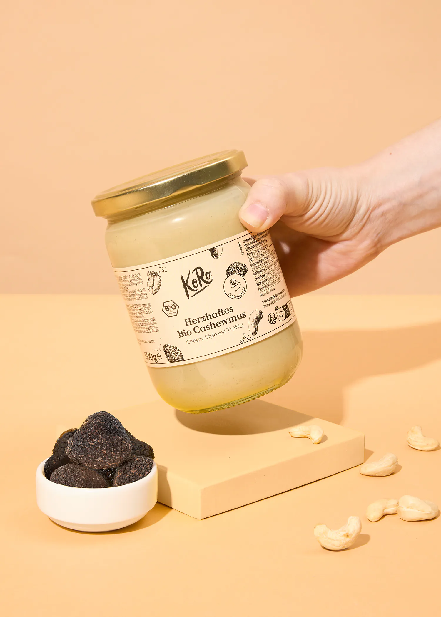 a person is holding a jar of herzhafter bio cashewmus