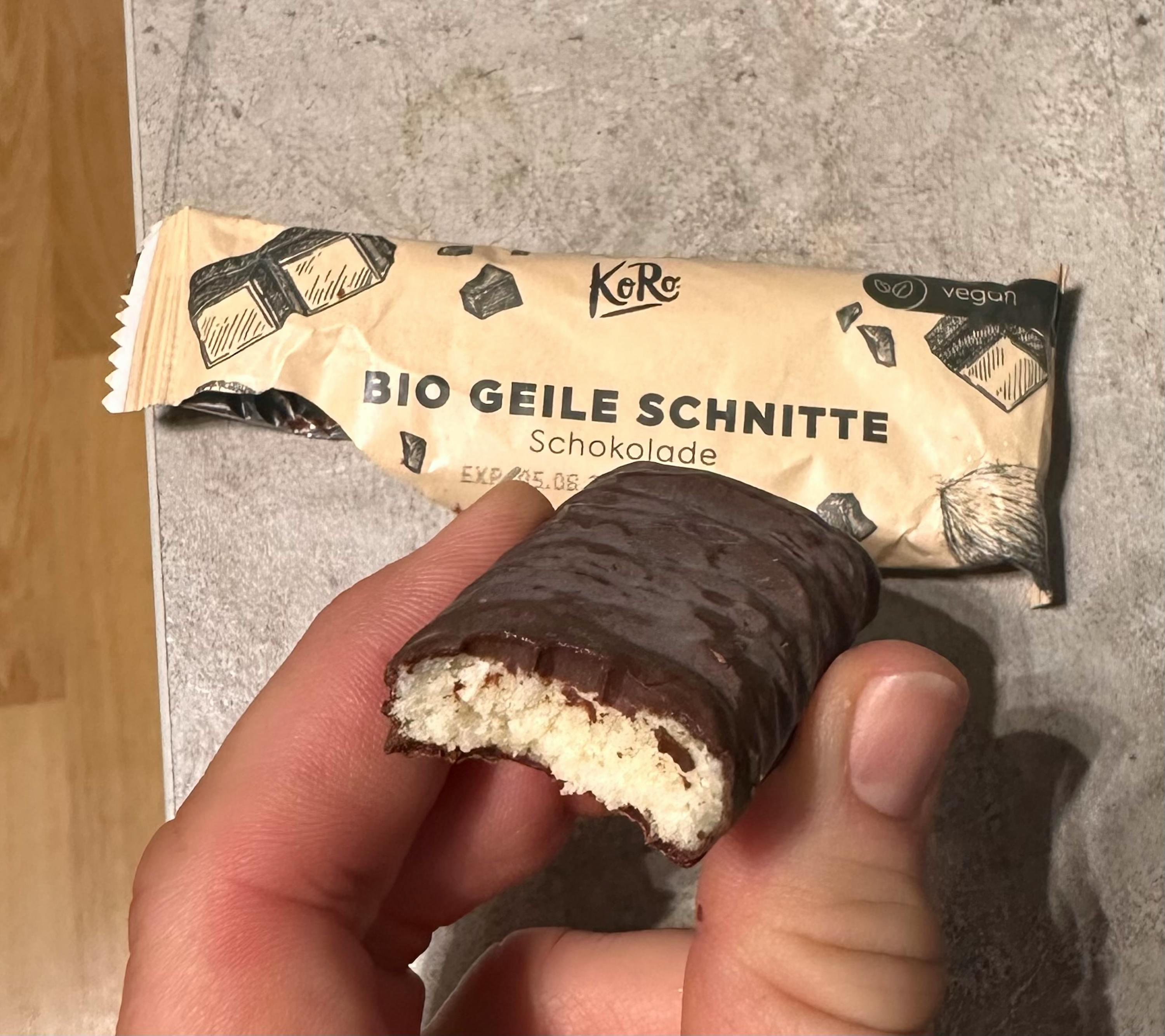 eine Person hält einen Schokoriegel mit einem Stück genommen