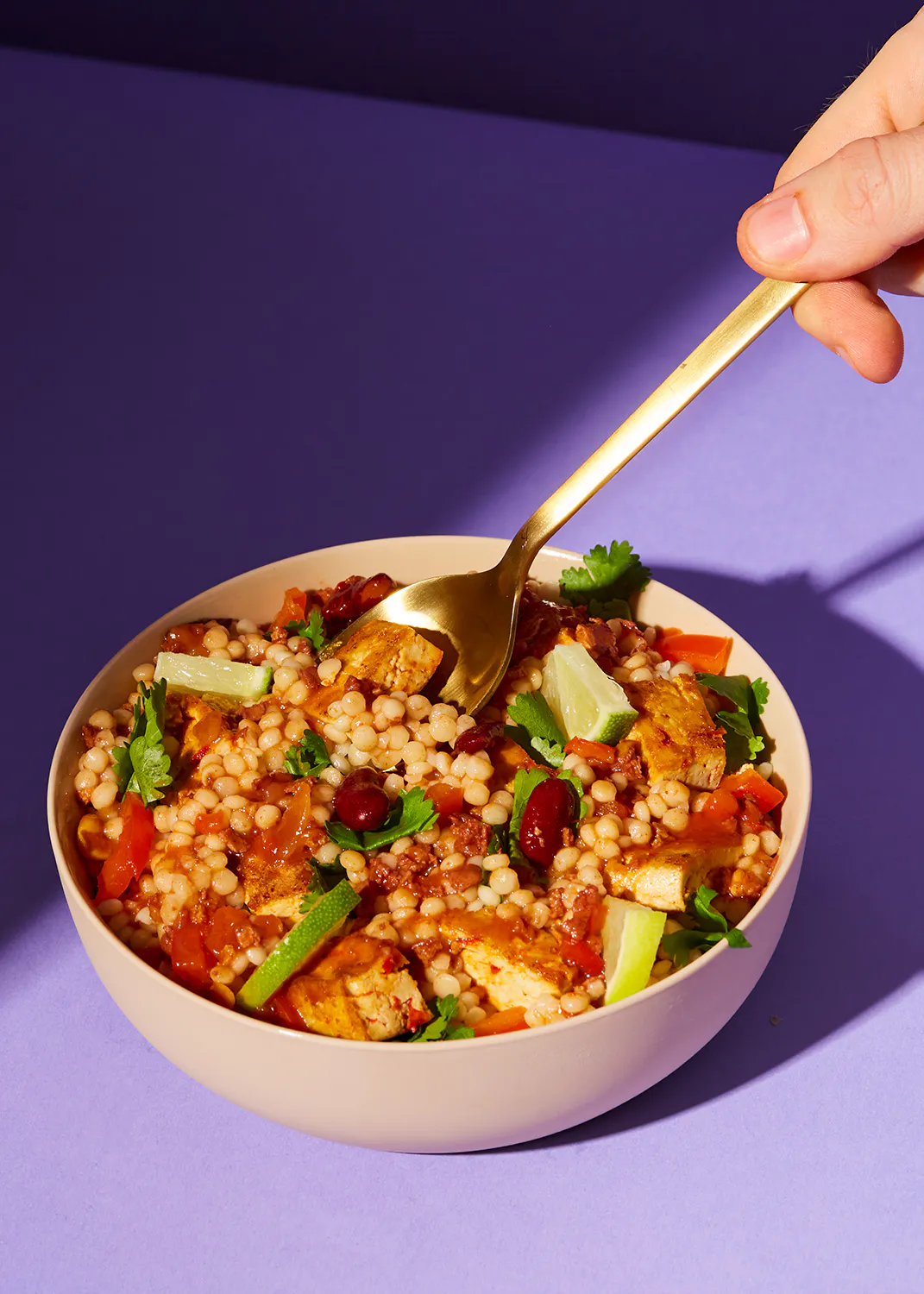 Person , die einen Löffel in eine Schüssel mit Essen hält