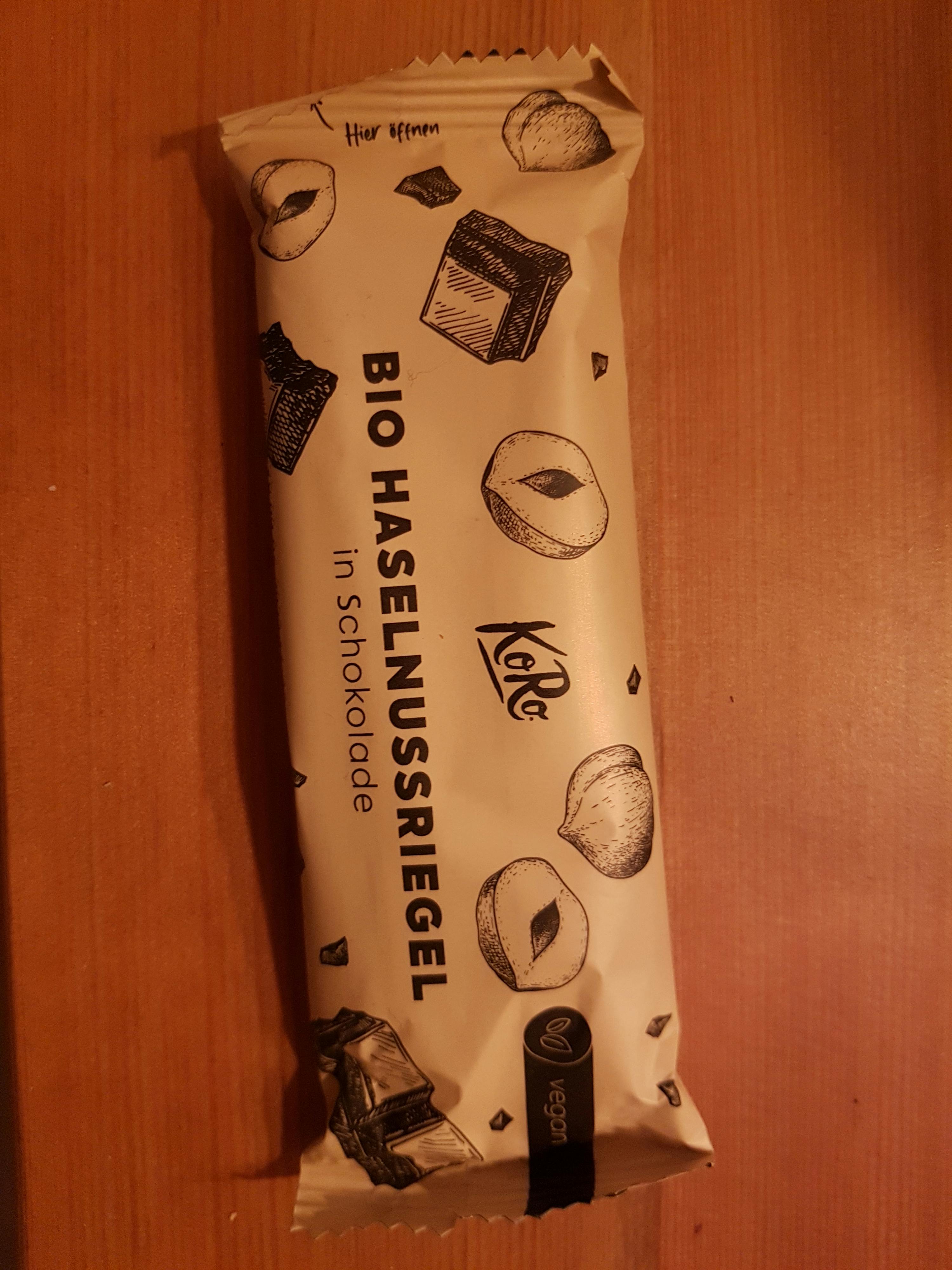 une barre de chocolat bio avec des noisettes sur une table en bois