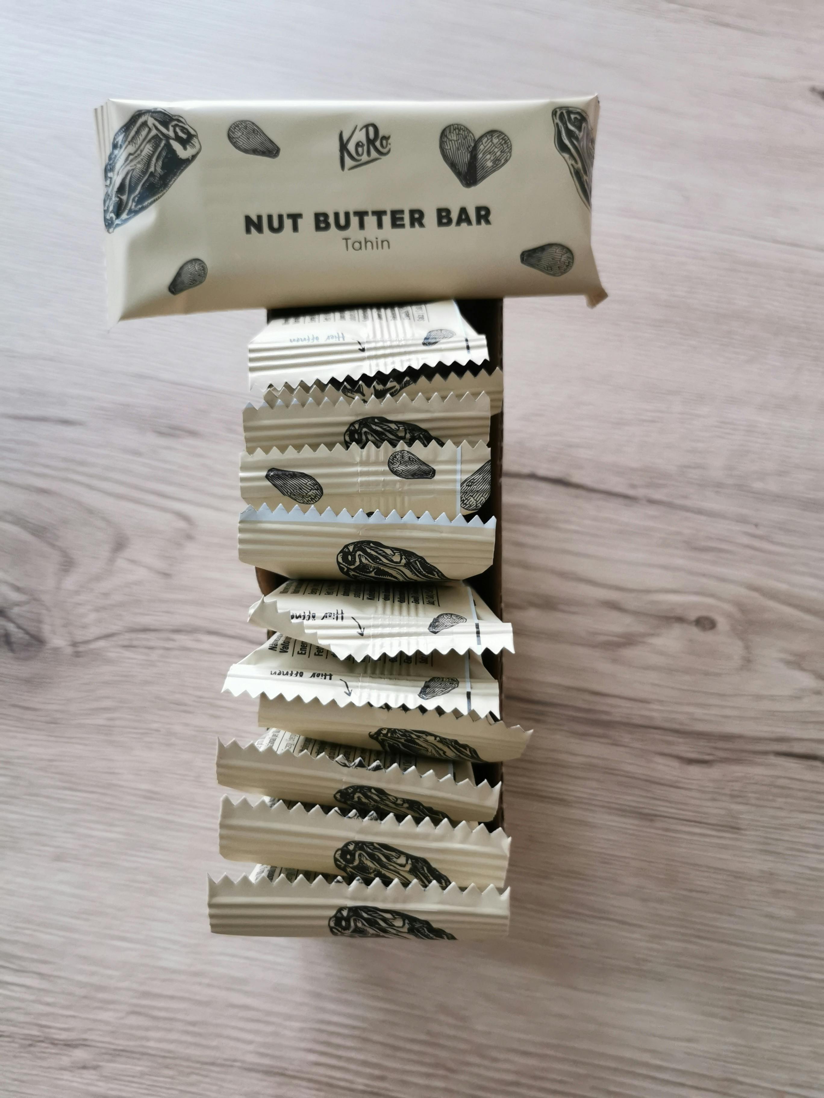 une barre de beurre de noix de tahin est empilée sur une table en bois