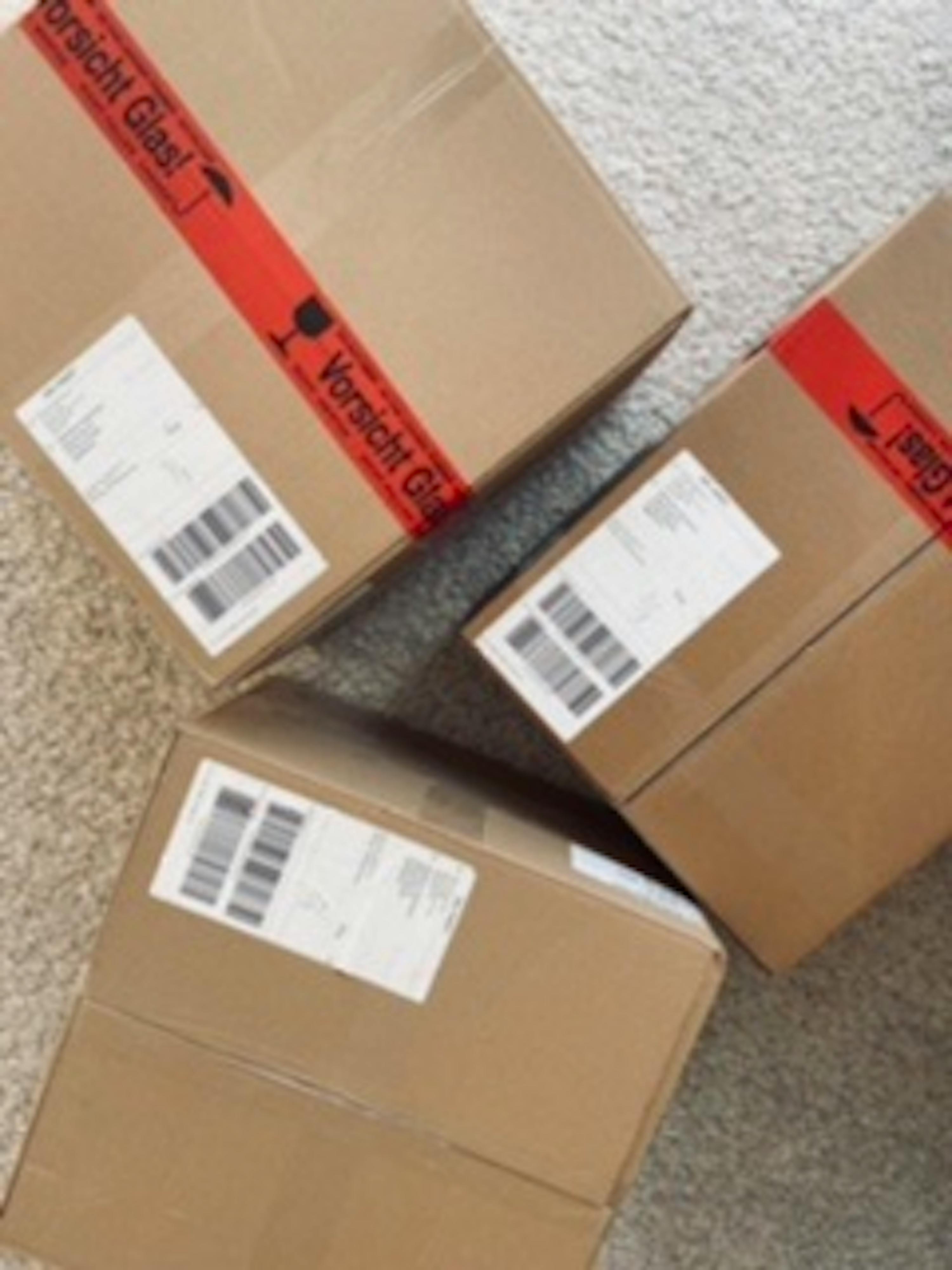 three cardboard boxes with a red tape that says ' vorsicht glas ' on it