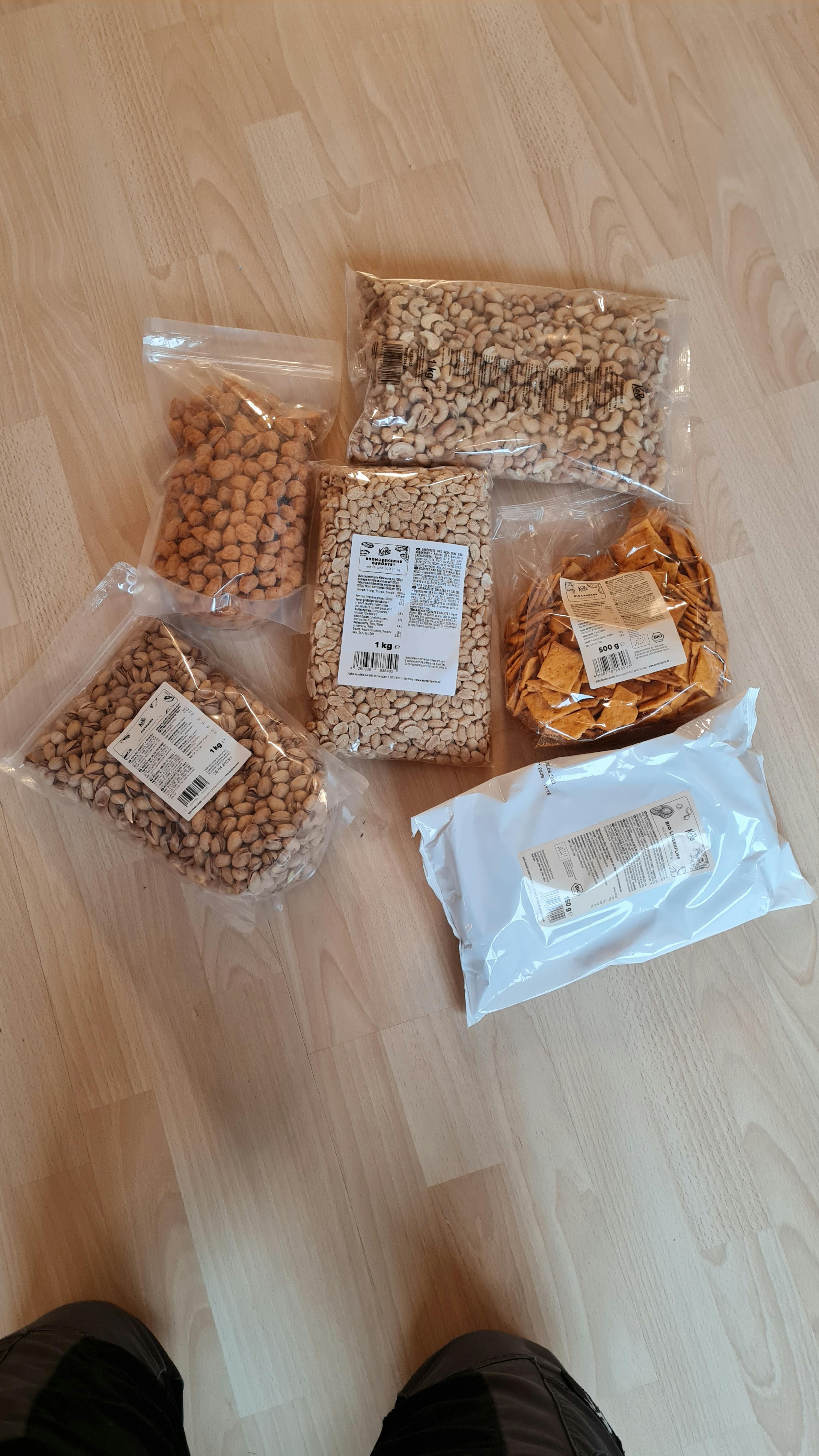 verschiedene Arten von Erdnüssen und Chips auf einem Holzboden