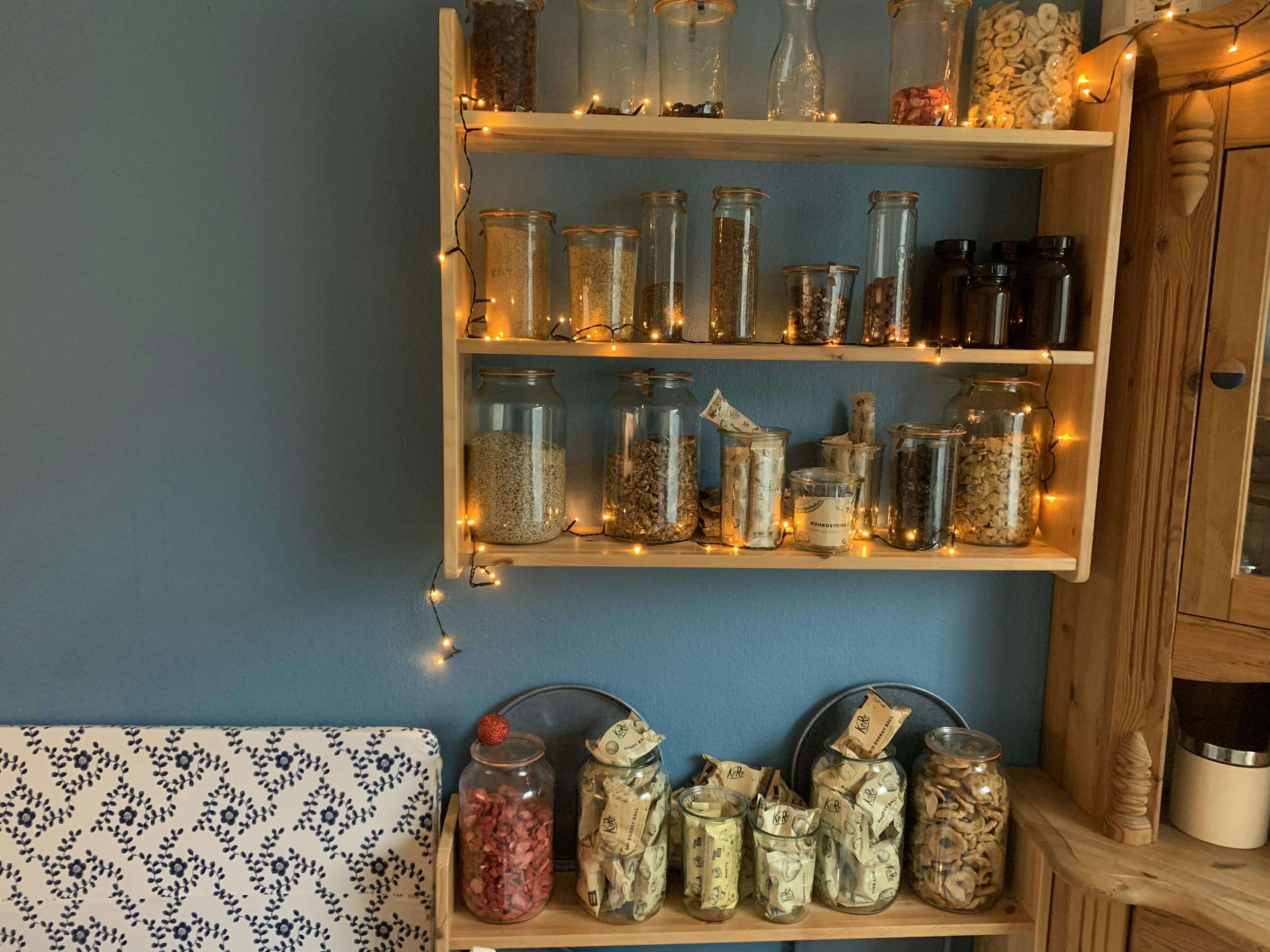 a shelf filled with jars and bottles including one that says ' strawberry ' on it