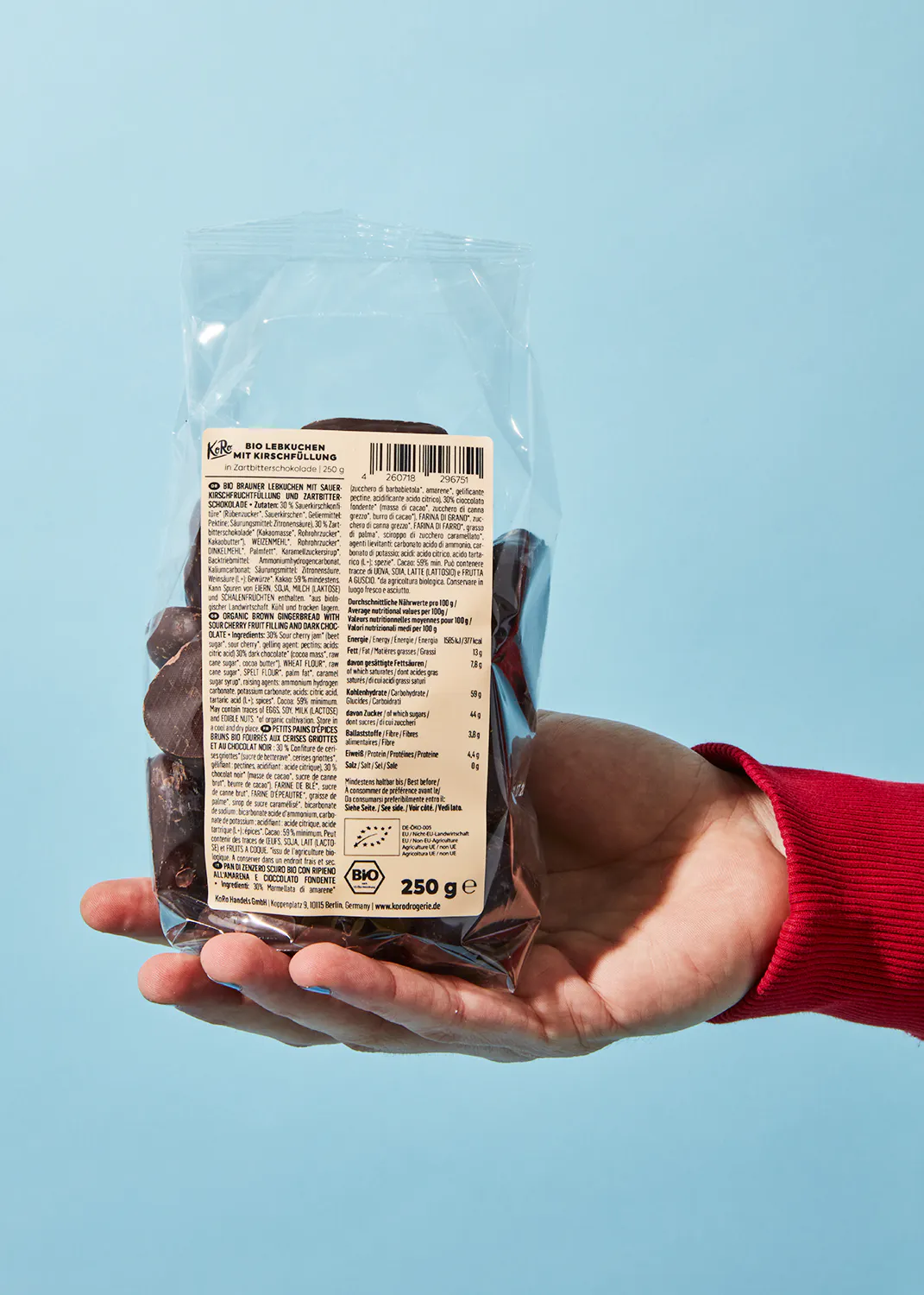 eine Person hält einen Plastikbeutel mit 250 g Schokolade in der Hand