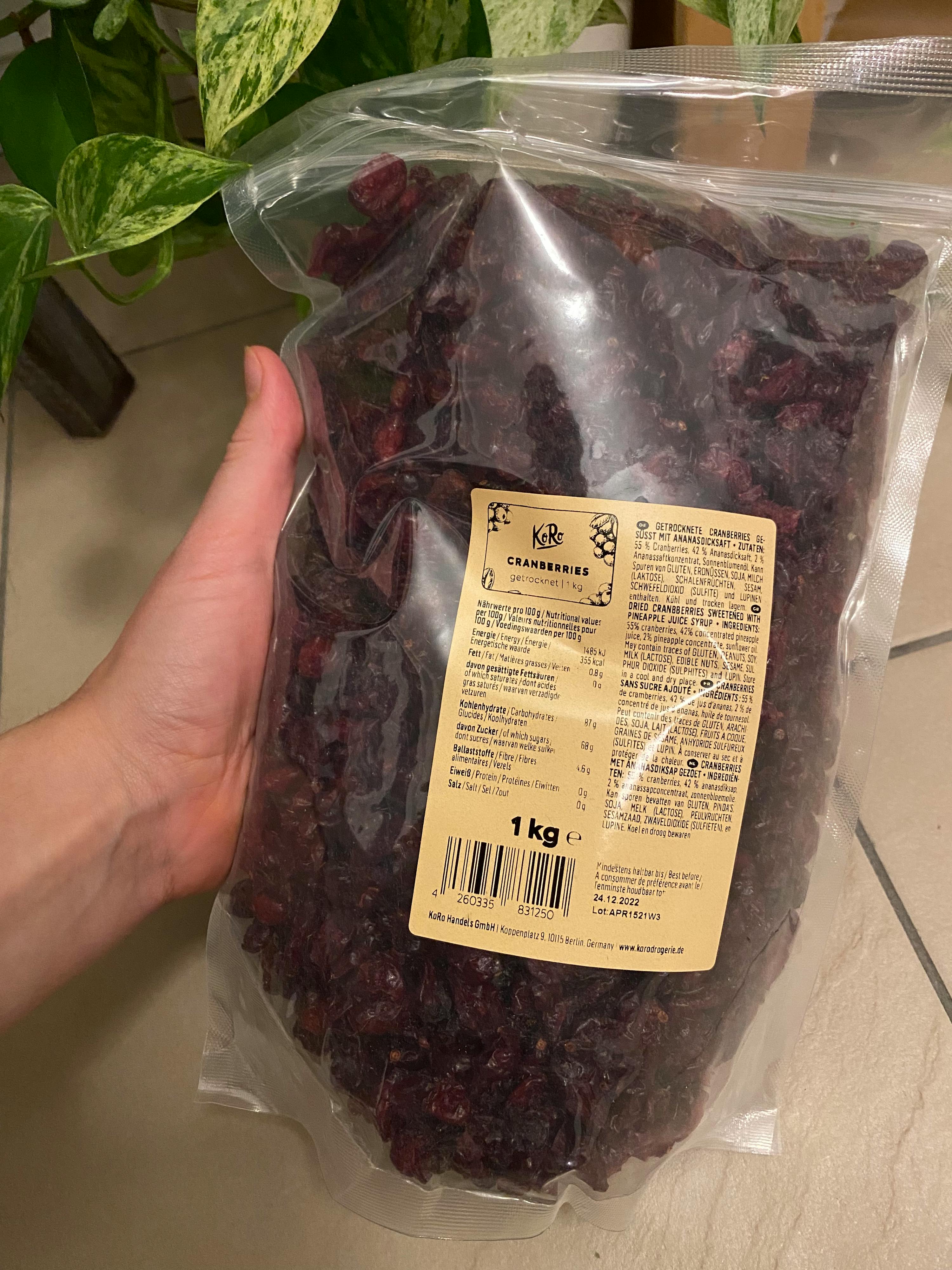 a person is holding a bag of dried cranberries