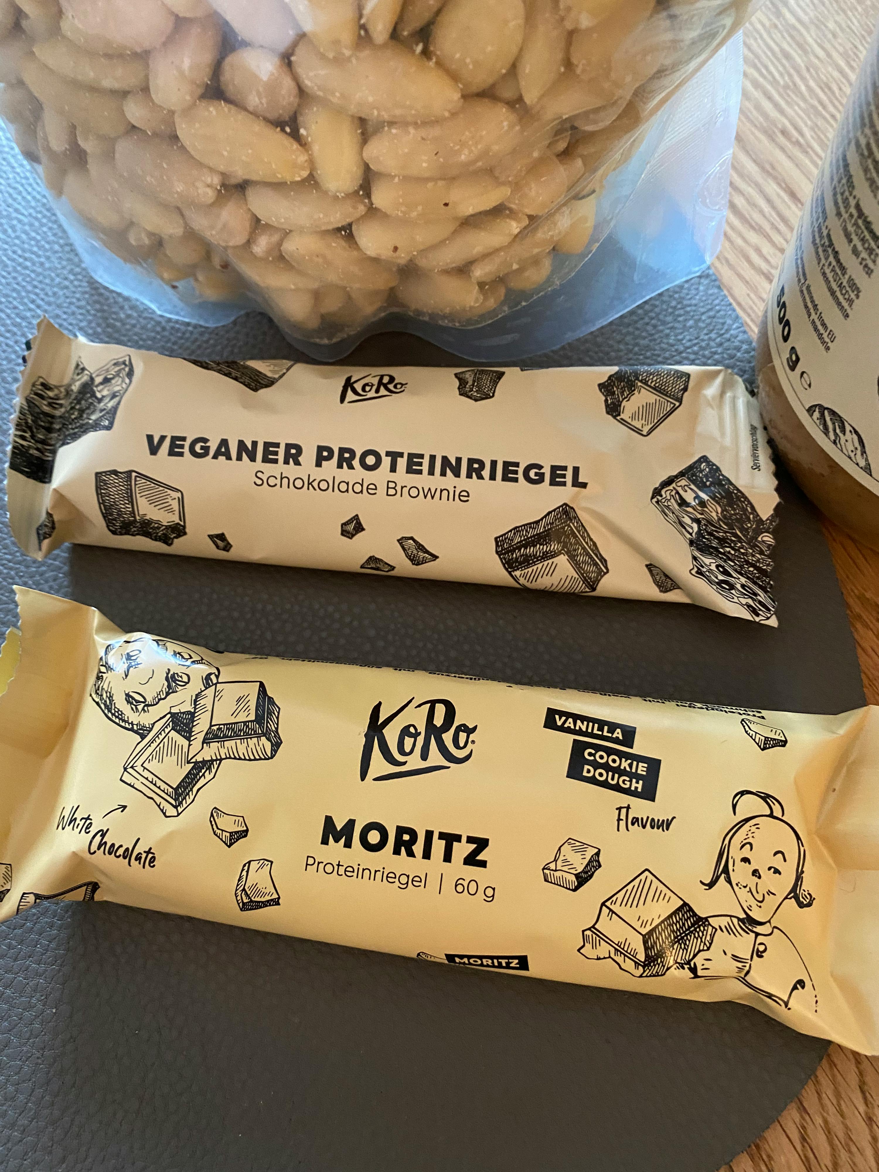 a package of veganer proteinriegel sits next to a package of moritz protein bar