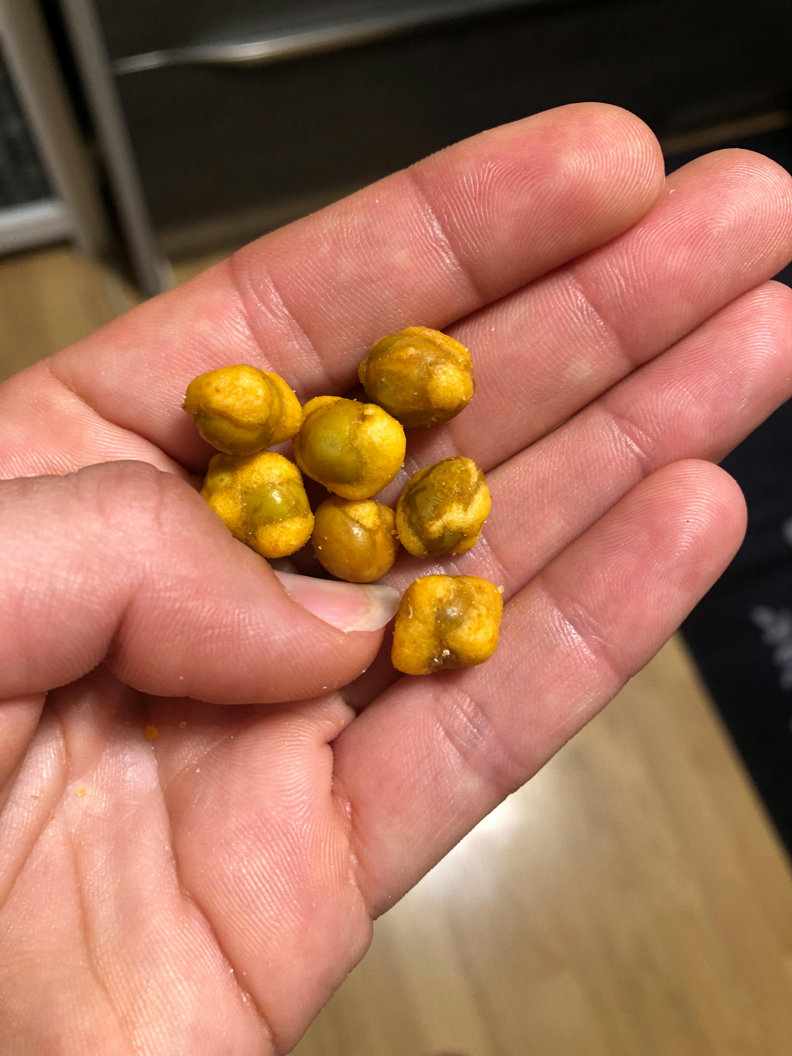 un primo piano di una persona che tiene in mano un mucchio di arachidi