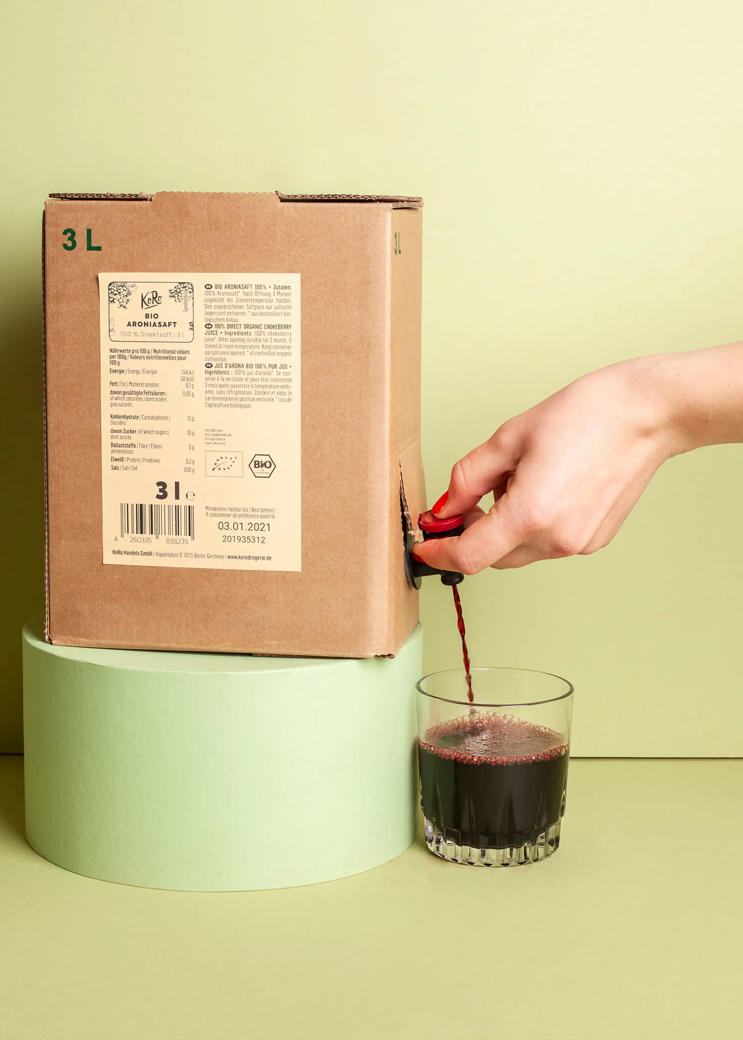 a person pouring a drink from a box that says 3l on it