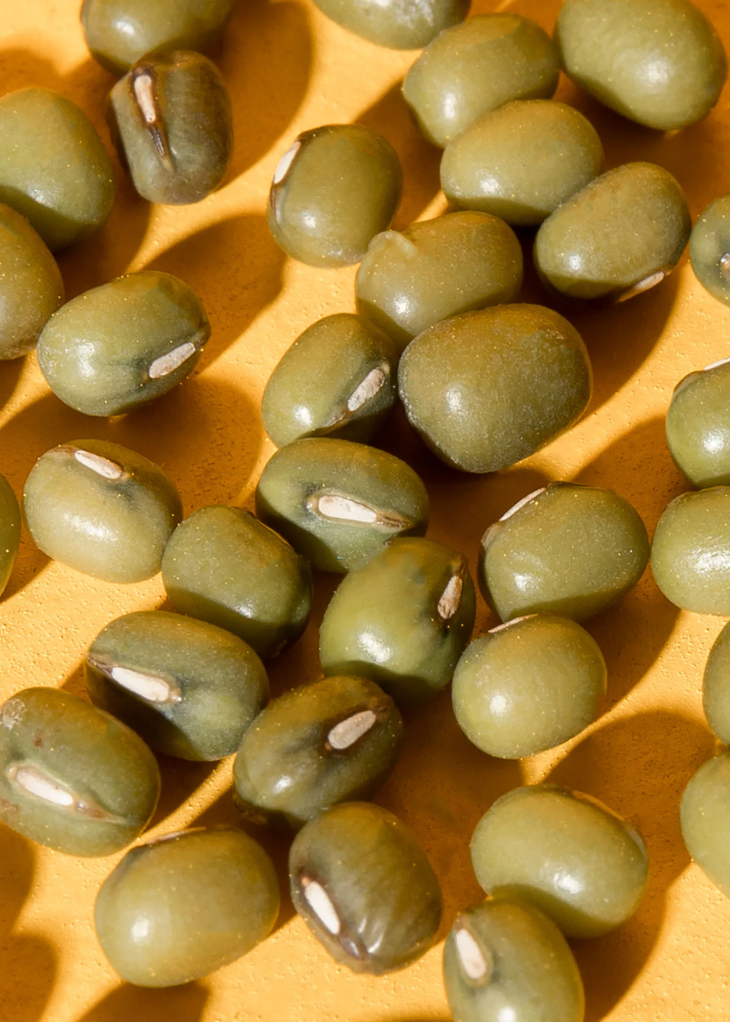 a pile of green beans on a yellow surface