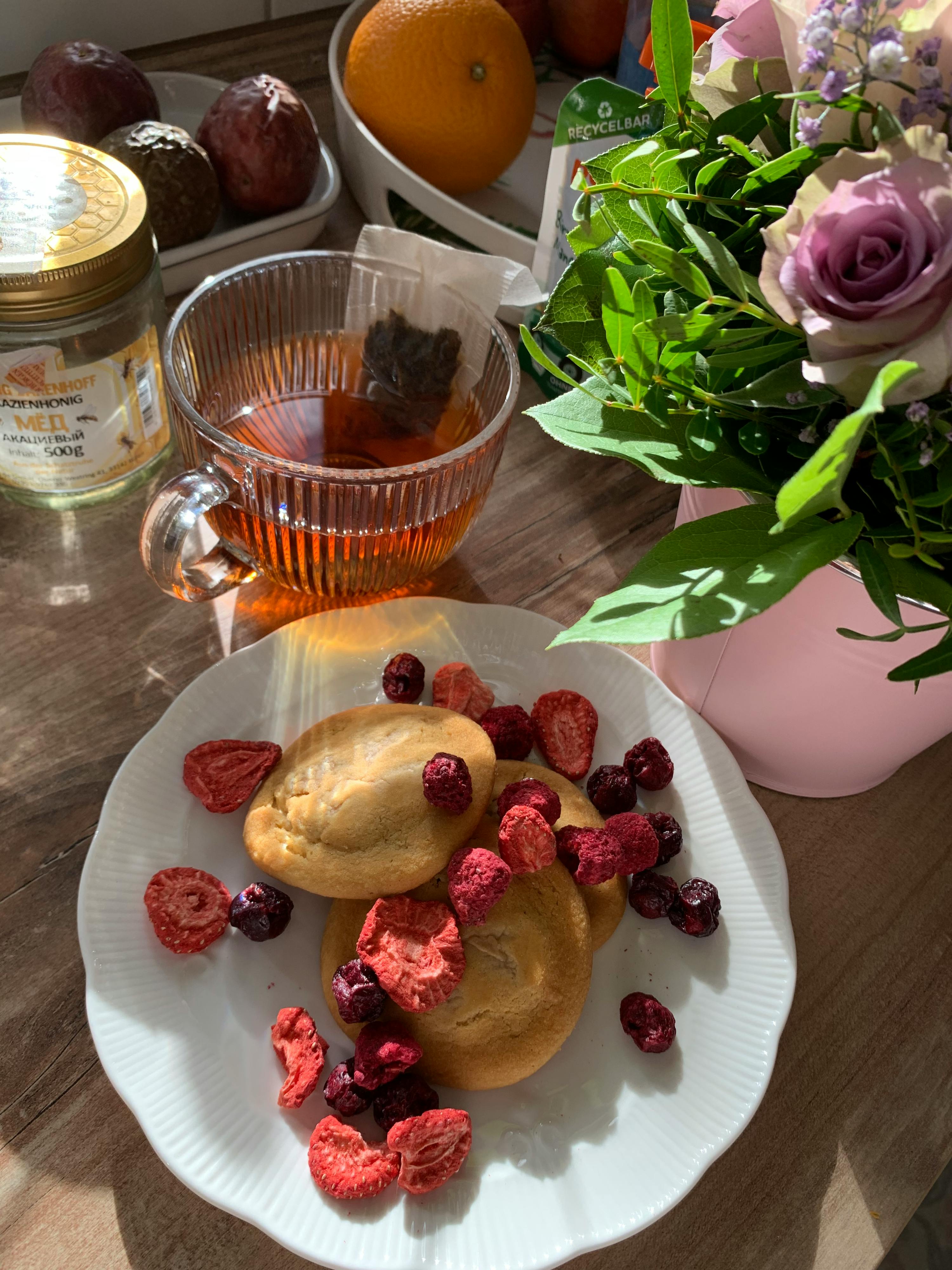 une assiette blanche avec des biscuits et des baies dessus