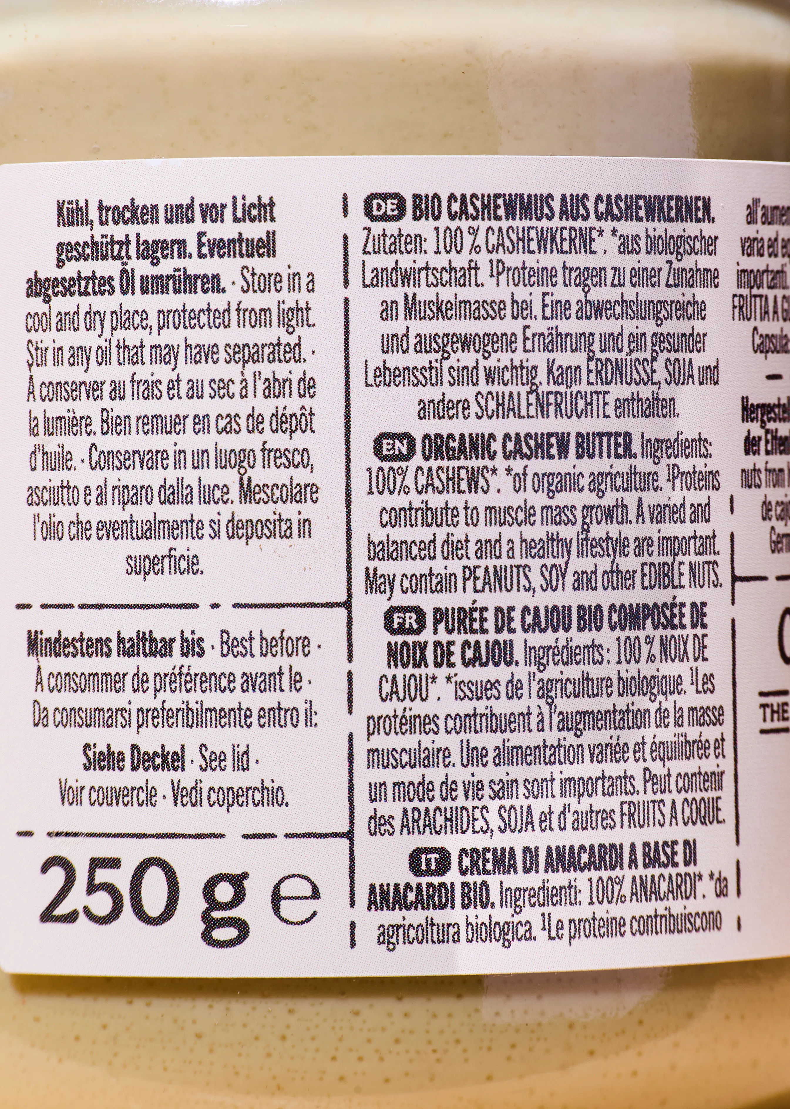etikett eines bio-cashewmus aus cashewkernen mit der angabe 250 g e, lagerhinweisen wie 'kühl, trocken und vor licht geschützt lagern. eventuell abgesetztes öl umrühren.' und dem vermerk 'mindestens haltbar bis siehe deckel'.