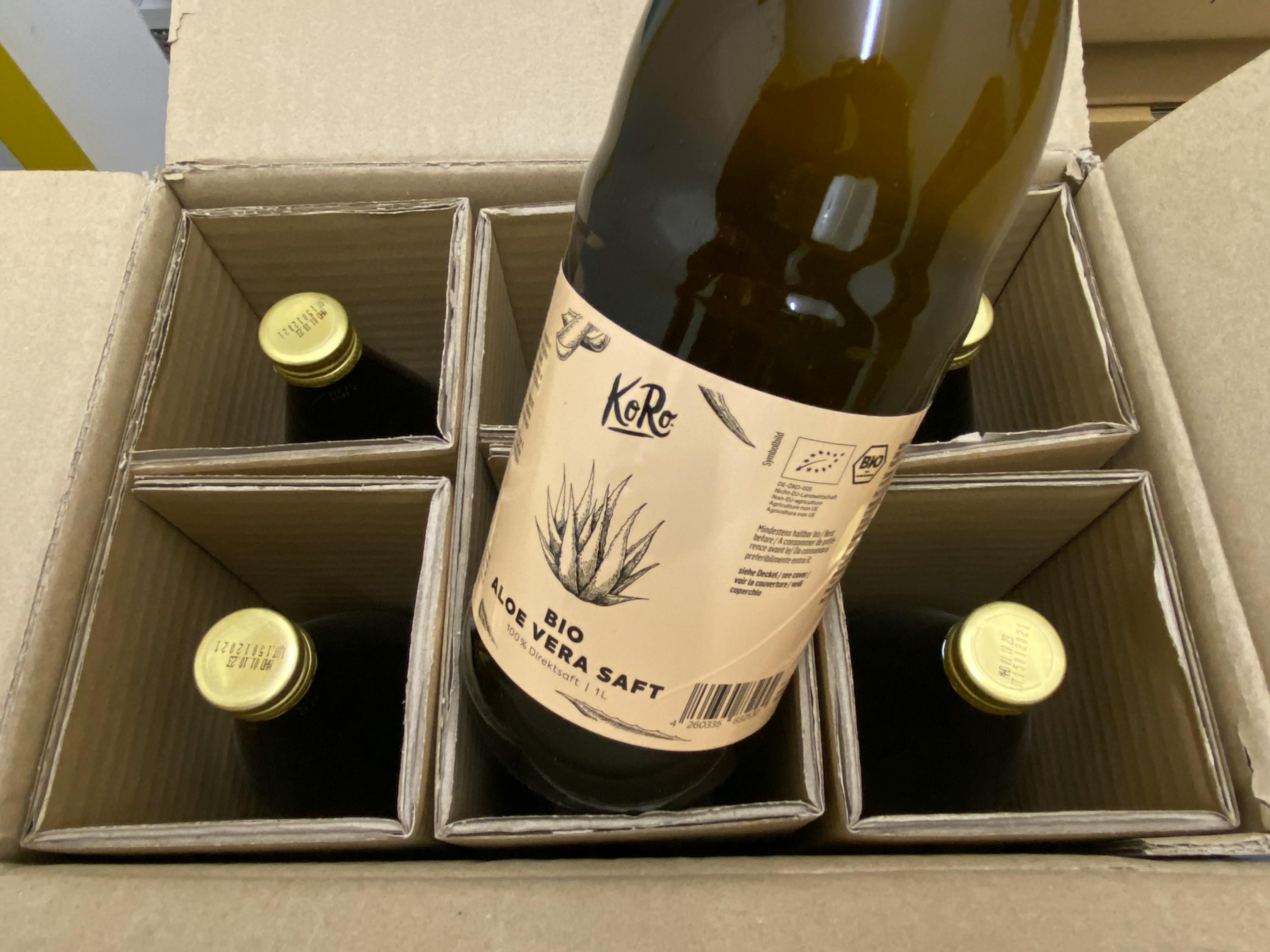 une bouteille d' aloe vera saft est assise à l' intérieur d' une boîte en carton