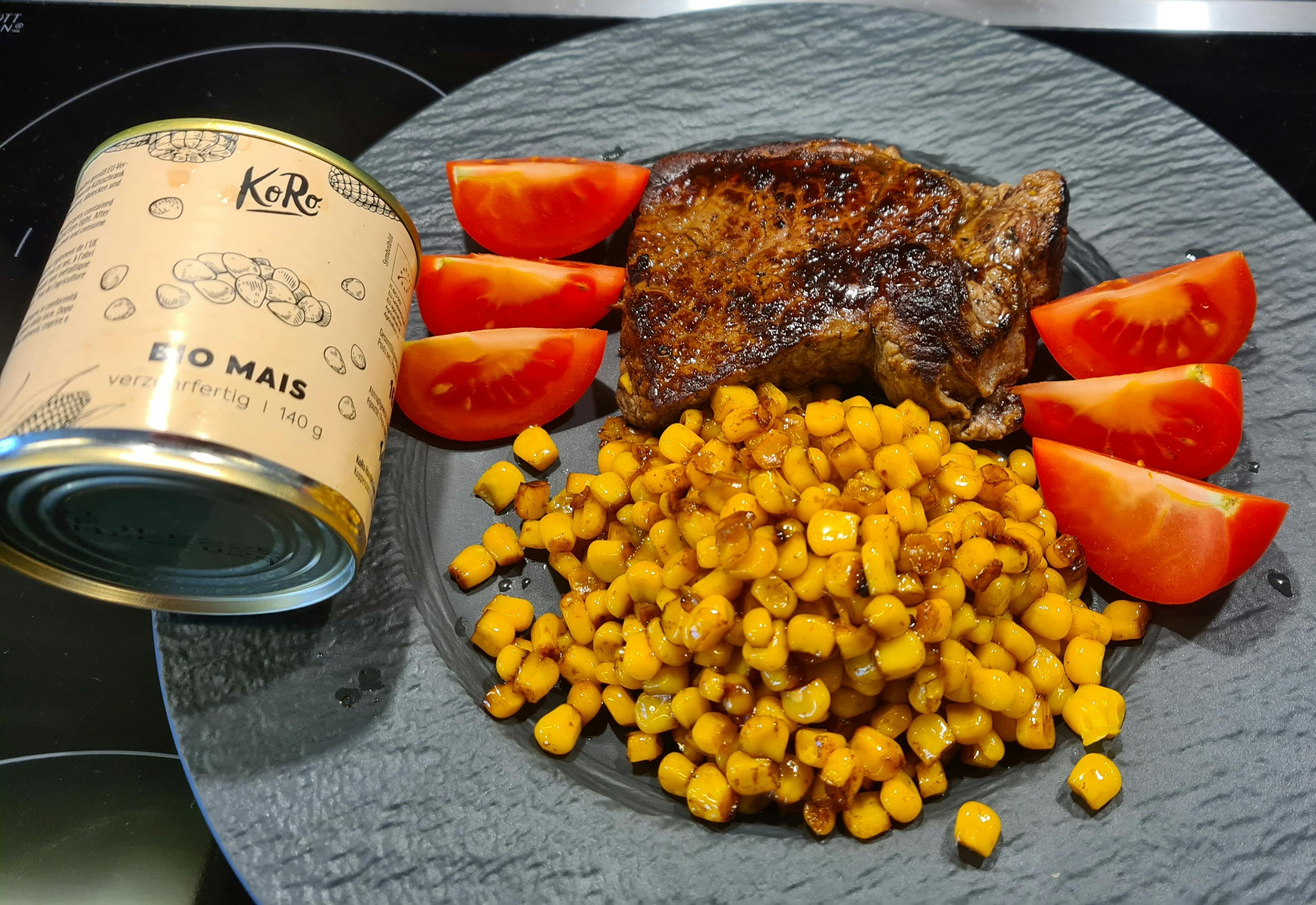 eine Dose Bio Mais neben einem Teller mit Essen