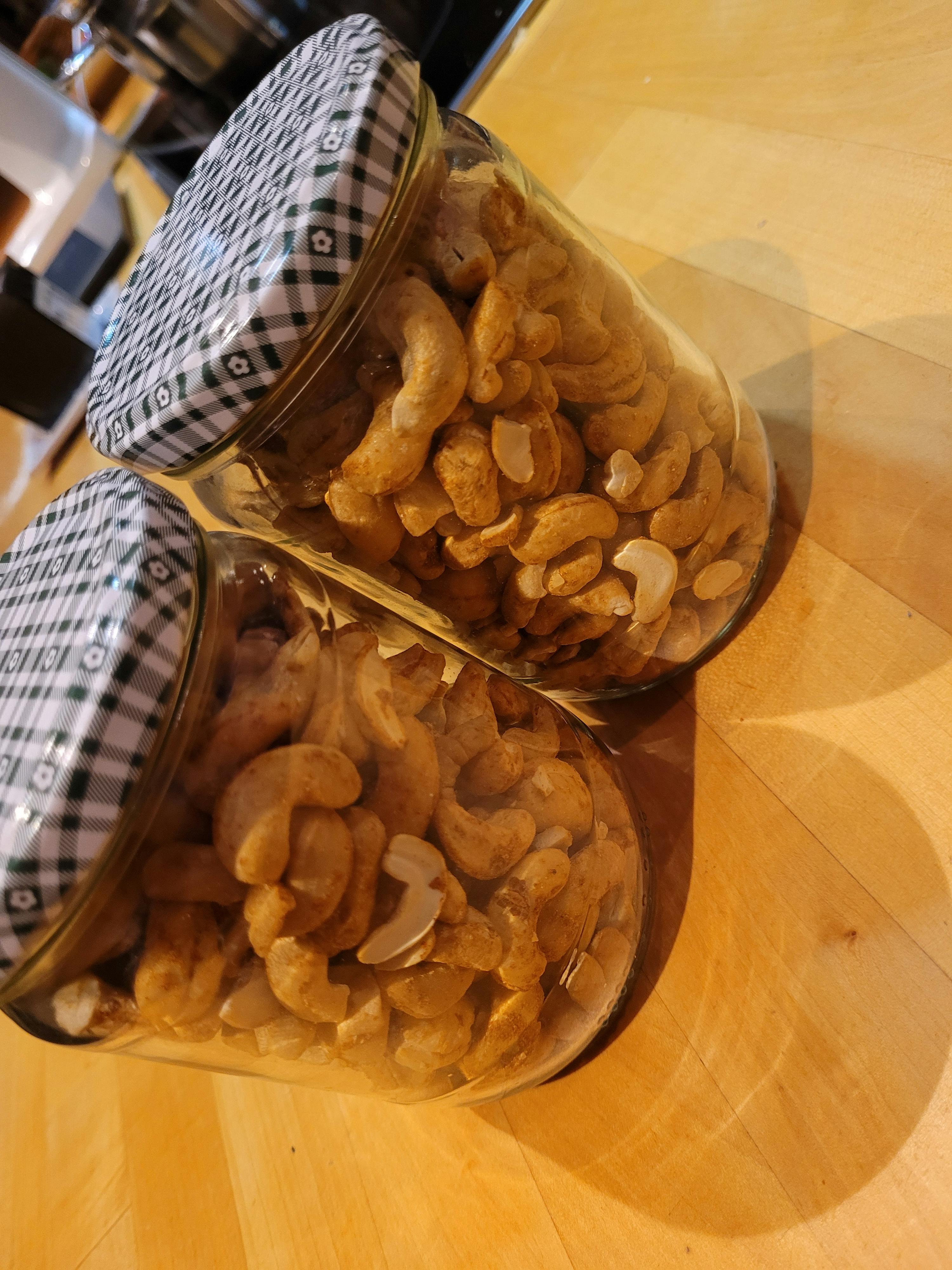 zwei Gläser mit Cashewnüssen auf einem Holztisch