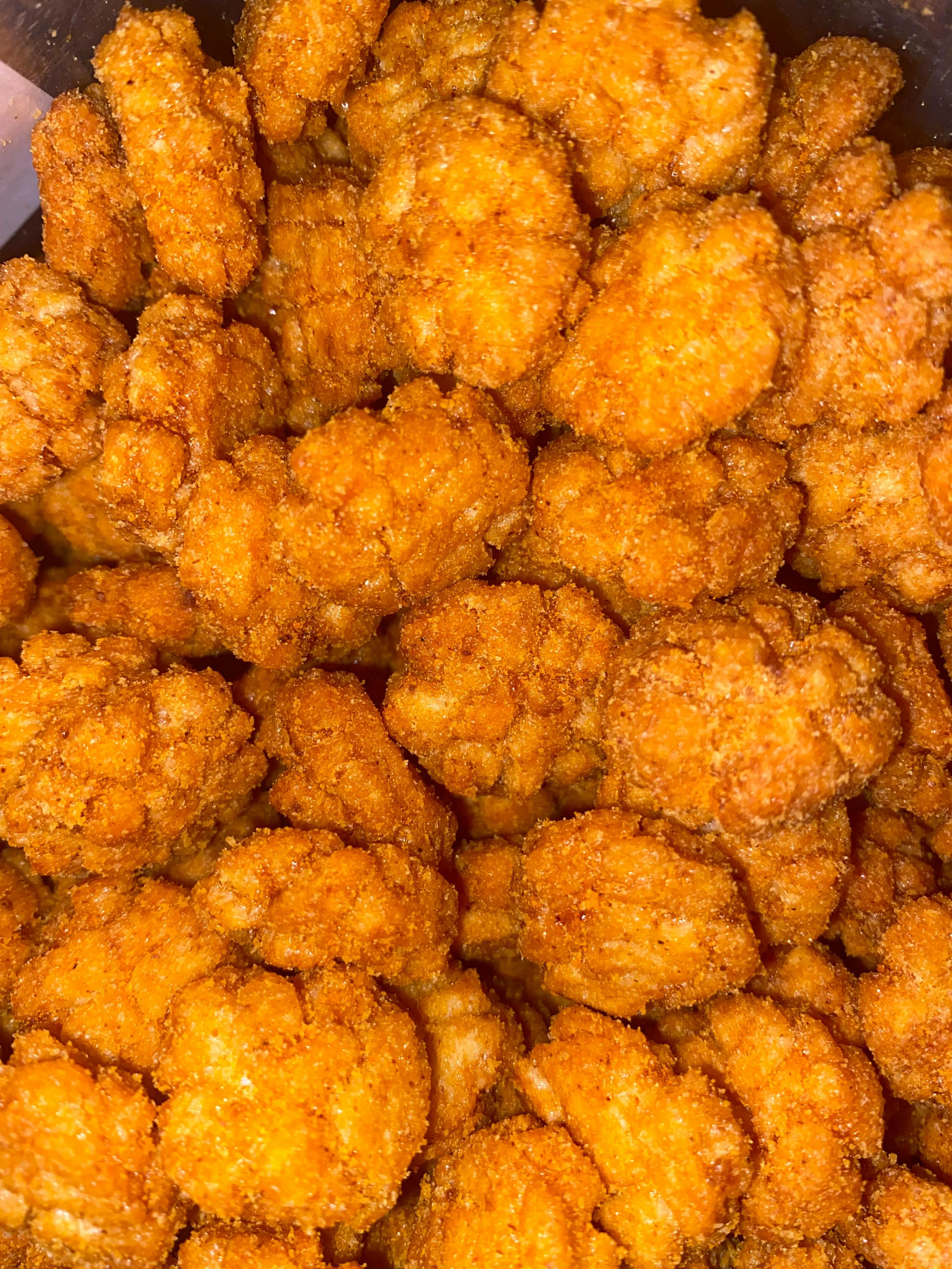 un gros plan d' un tas de frites de poulet