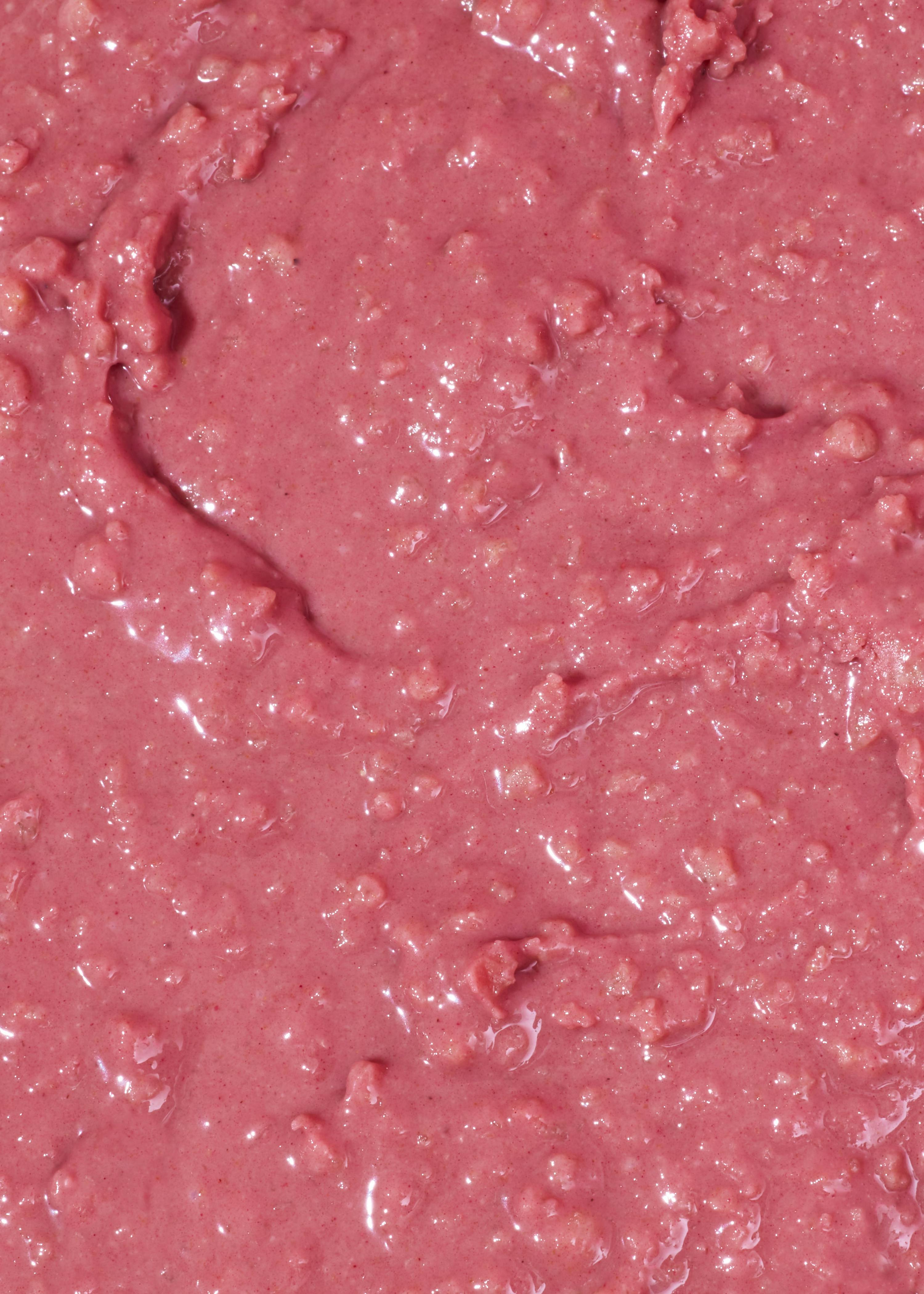 nahaufnahme einer dicken, rosafarbenen, körnigen masse mit glänzenden stellen.