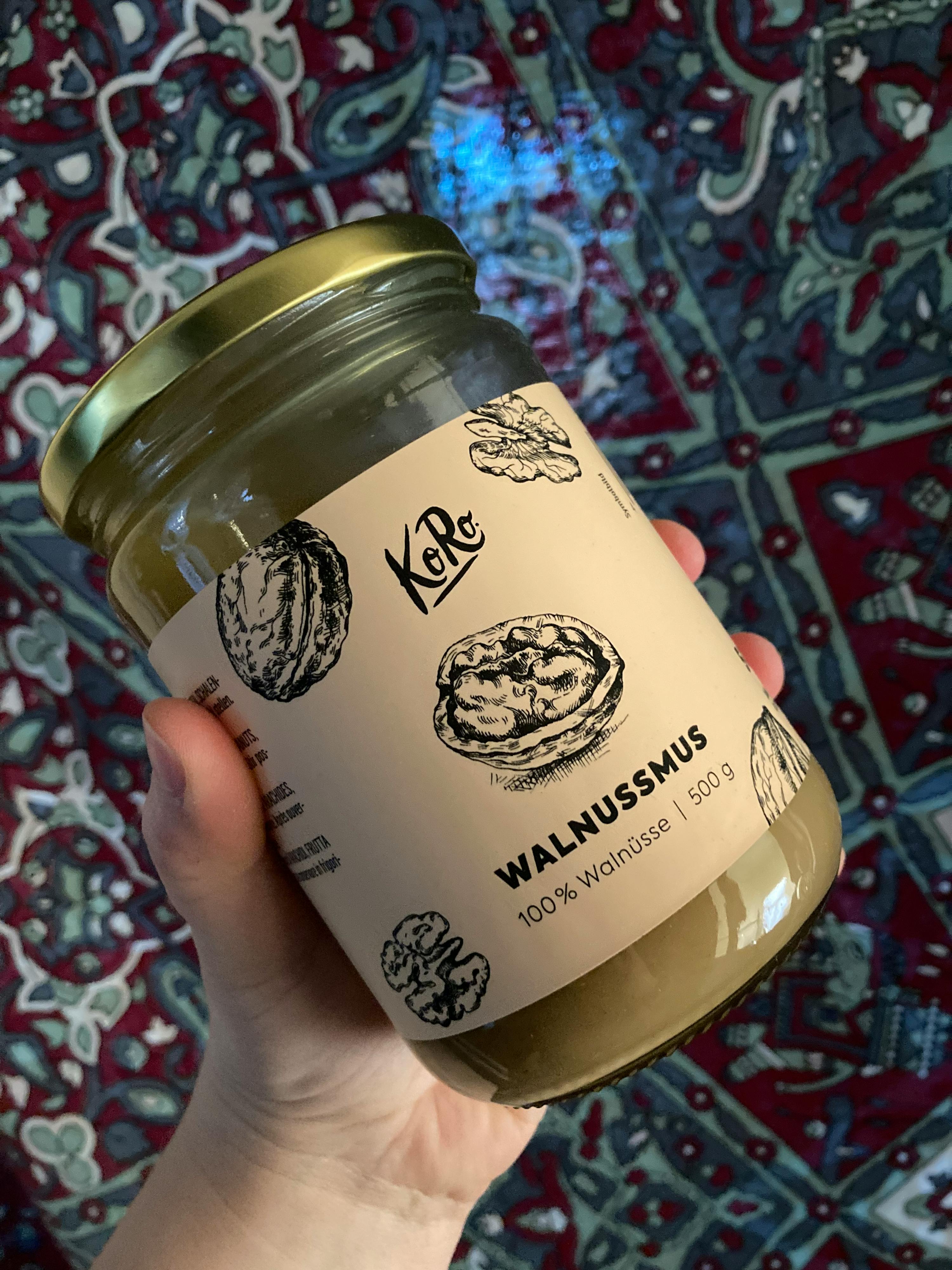 a person is holding a jar of walnutmus in their hand