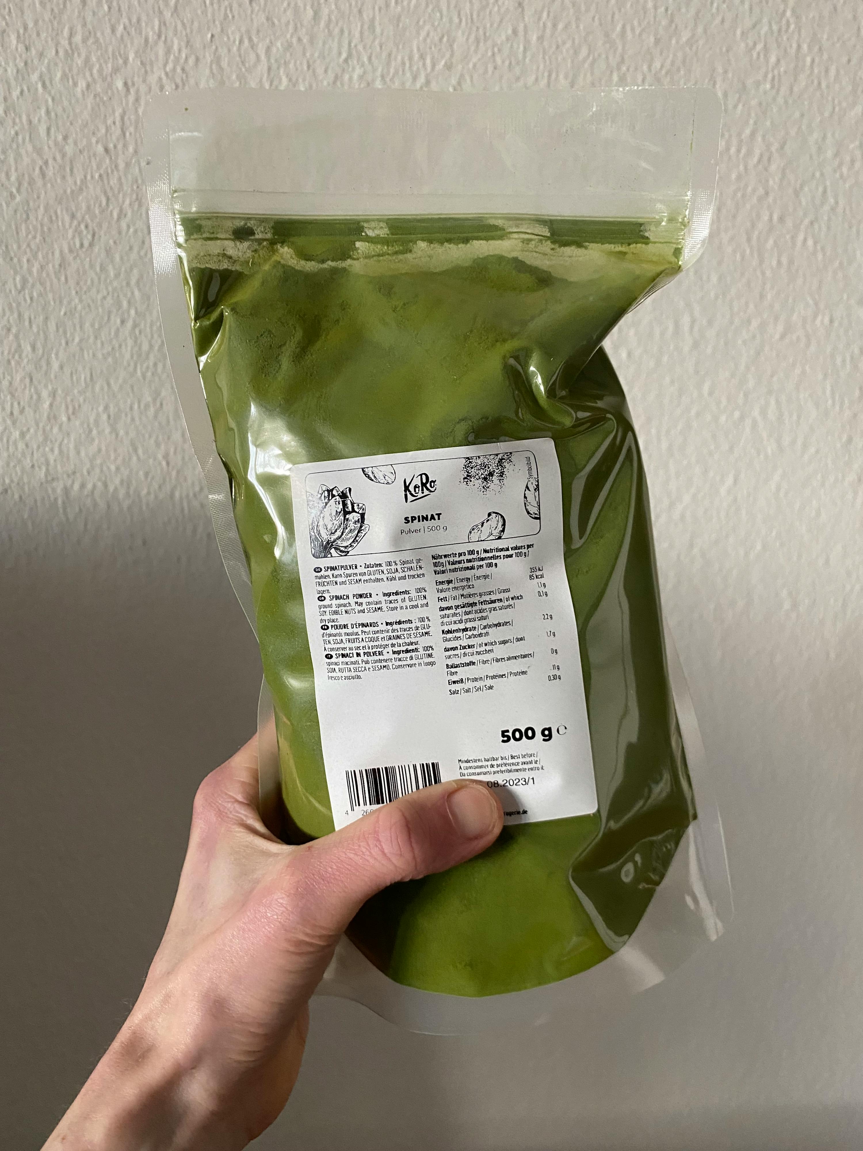 a person is holding a bag of green powder that says 500 g
