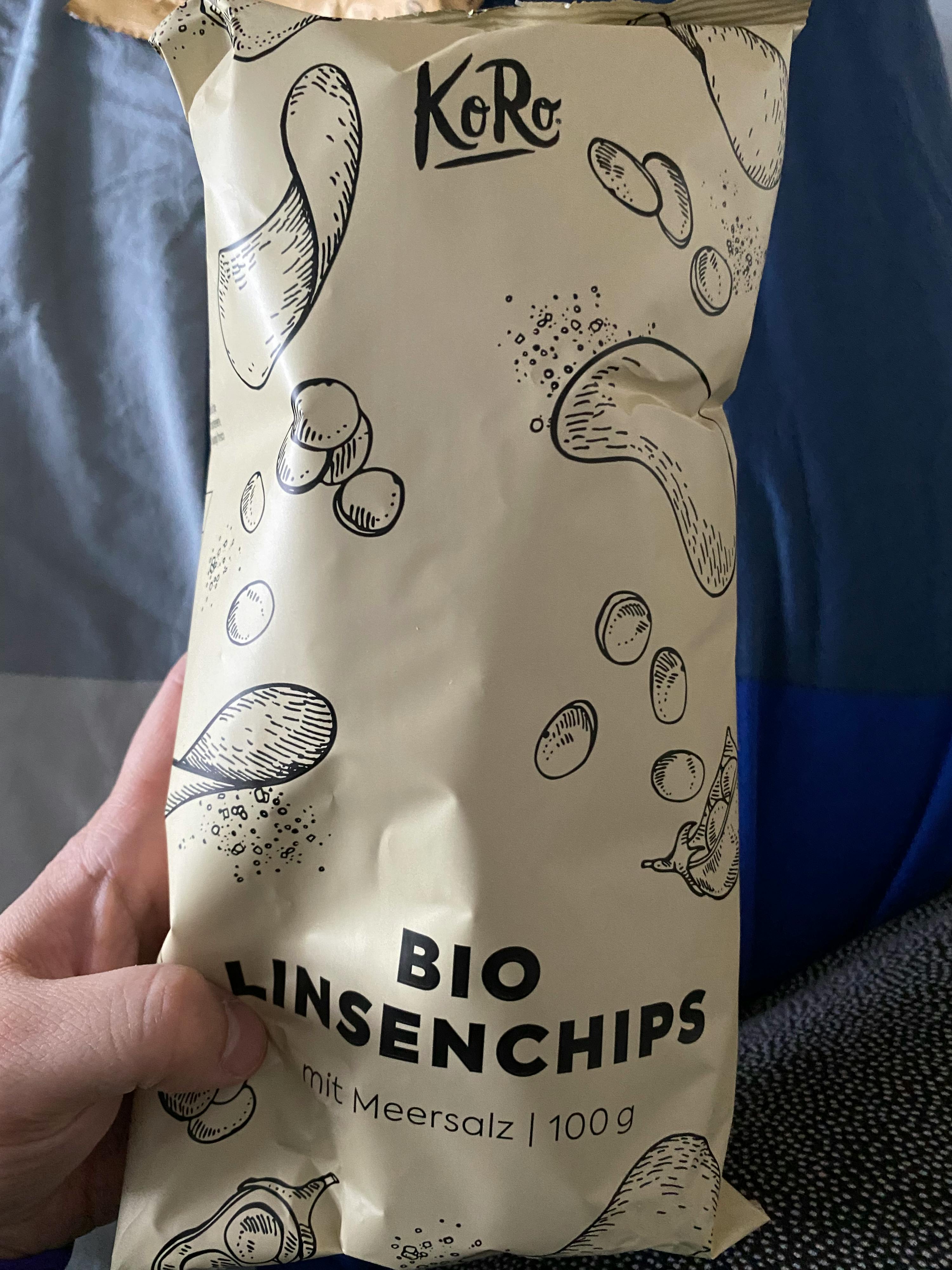eine Person hält eine Tüte Linsenchips in ihrer Hand