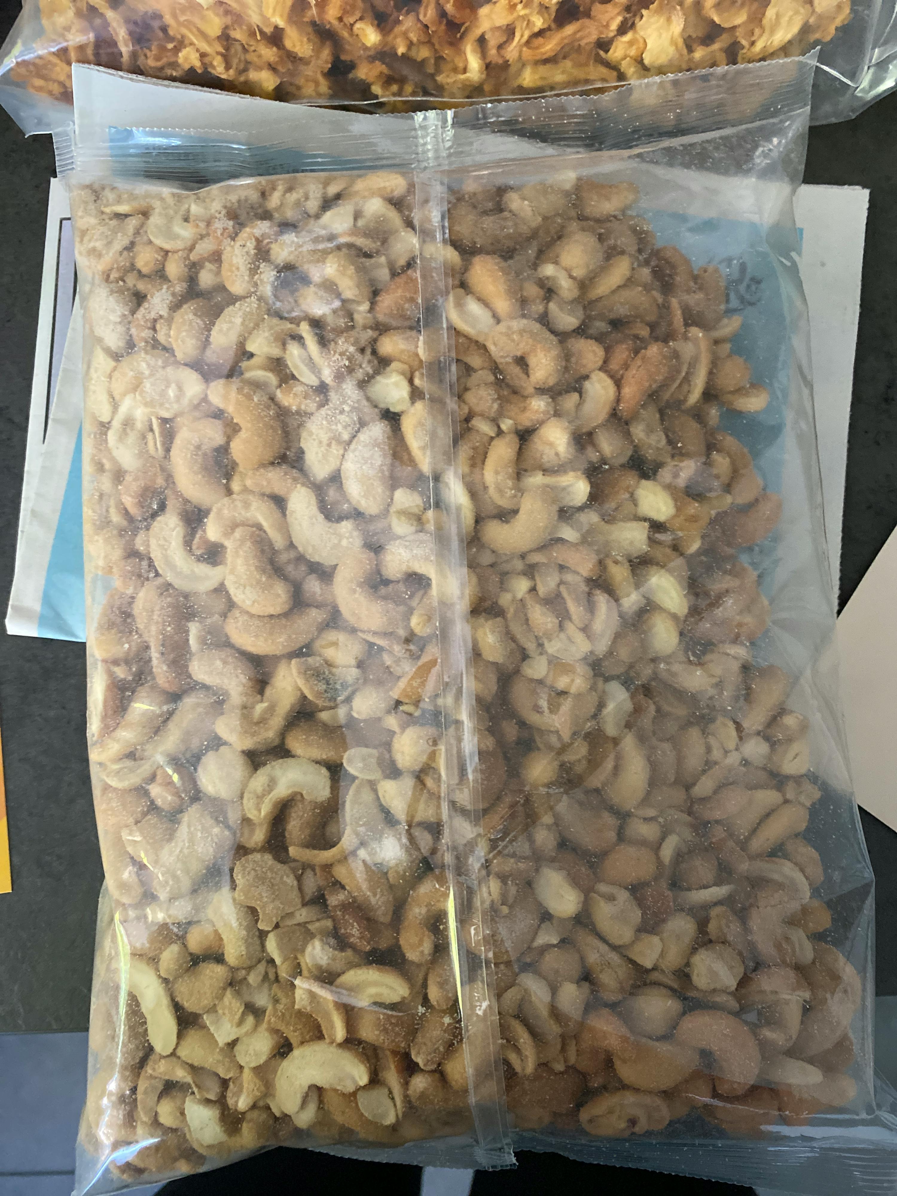 eine Plastiktüte mit gerösteten Cashewnüssen liegt auf einem Tisch