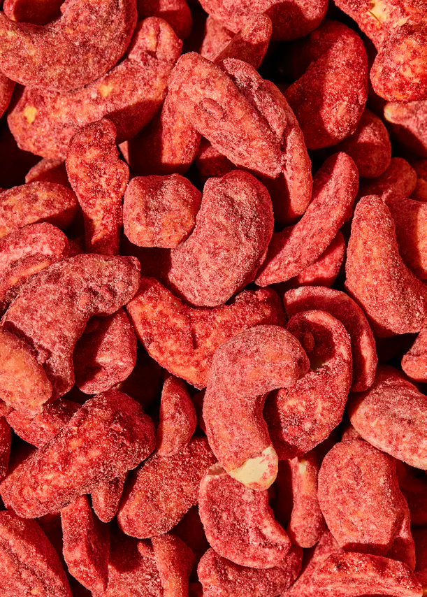 eine Nahaufnahme eines Haufens rot gezuckerter Cashewnüsse