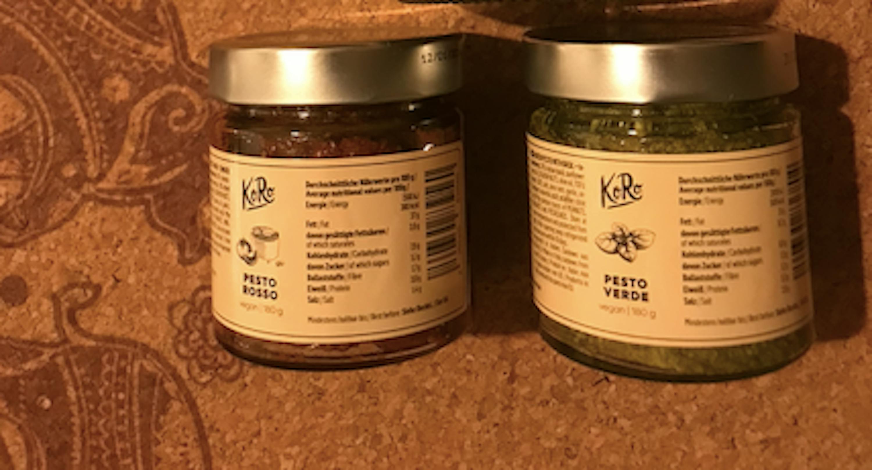 zwei Gläser mit pesto rosso und pesto verde stehen nebeneinander