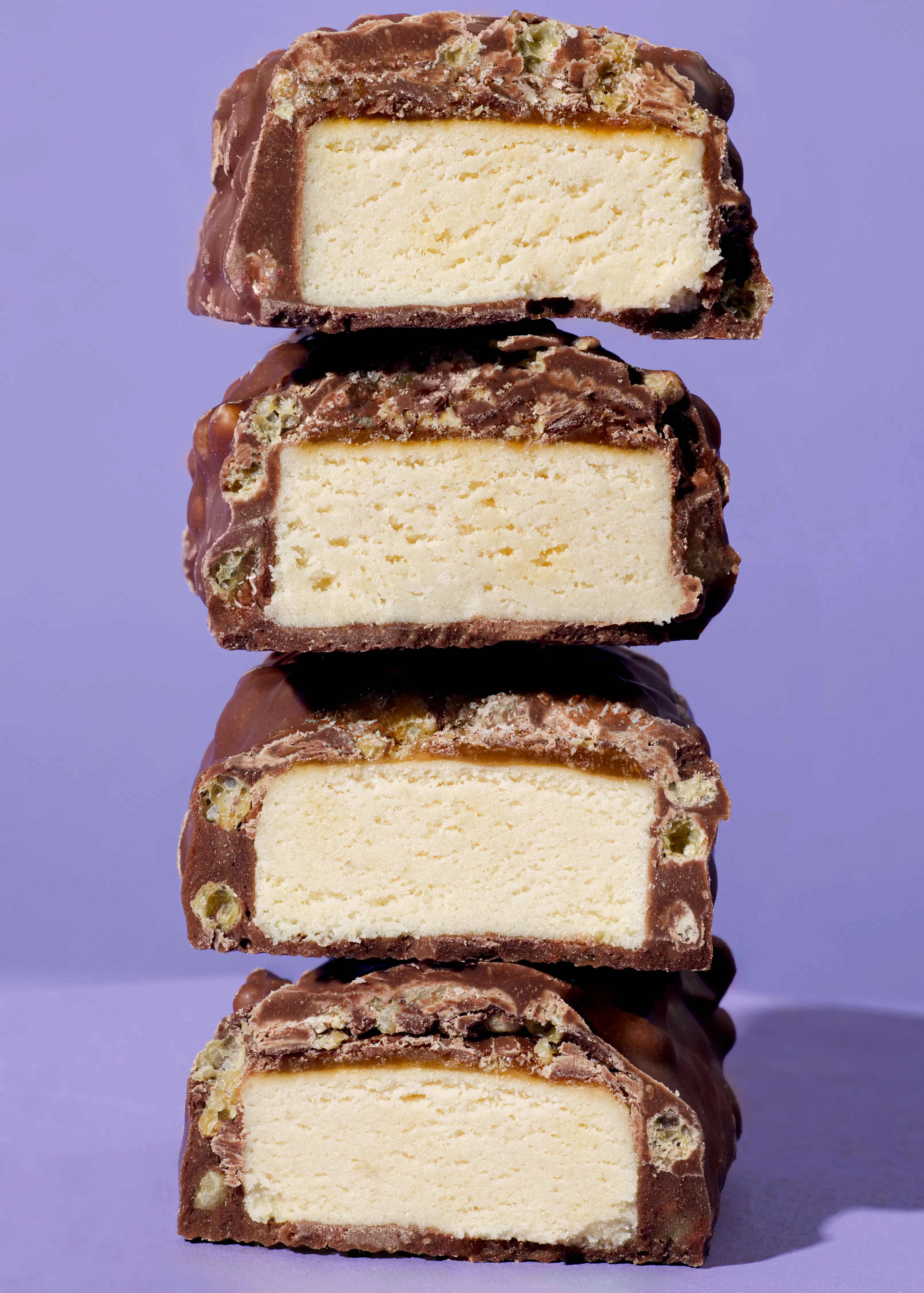 quatre barres de crème glacée sont empilées les unes sur les autres sur un fond violet