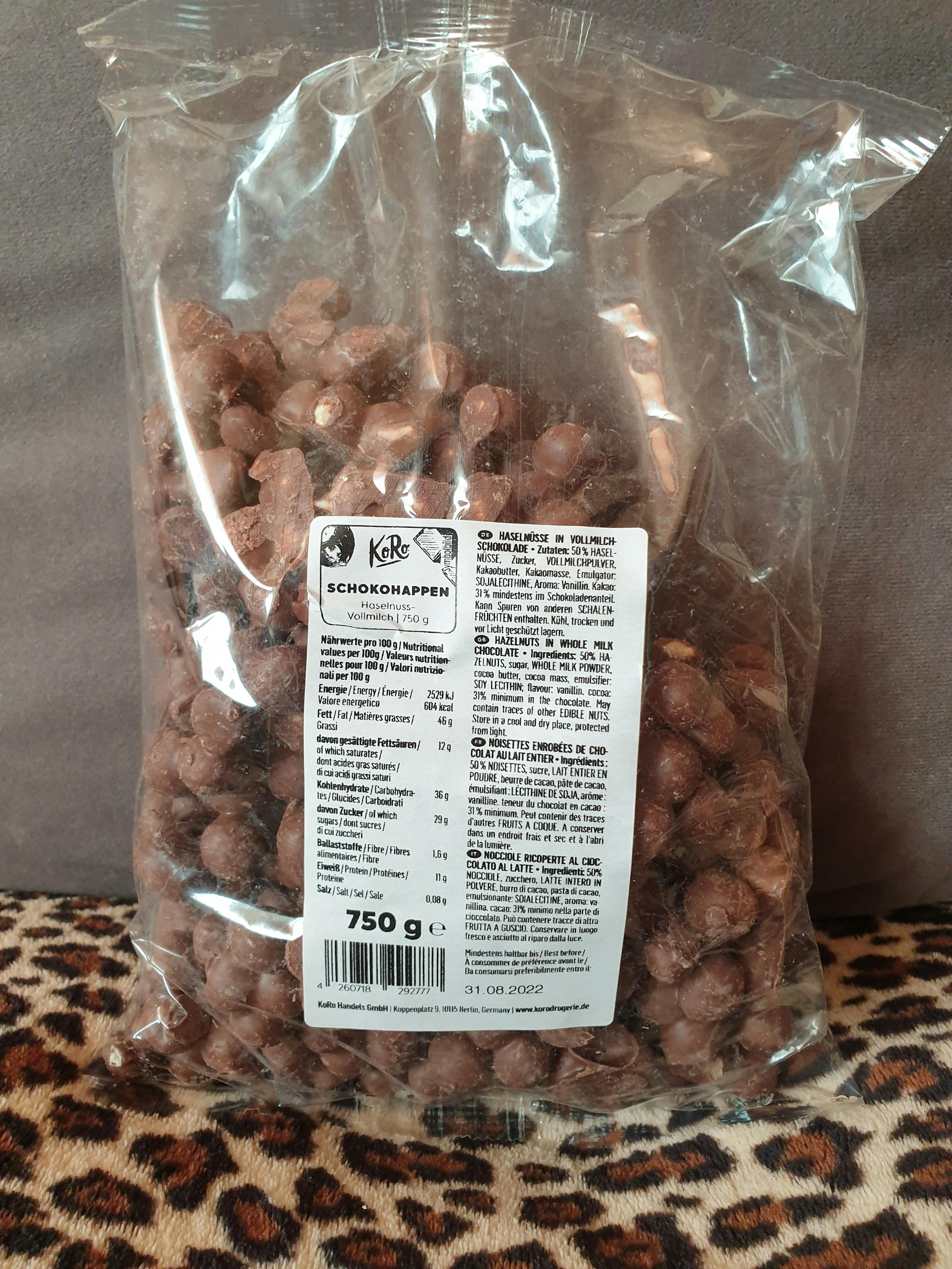 eine Tüte Schokoladenwürfel steht auf einem Leopardenmustersofa