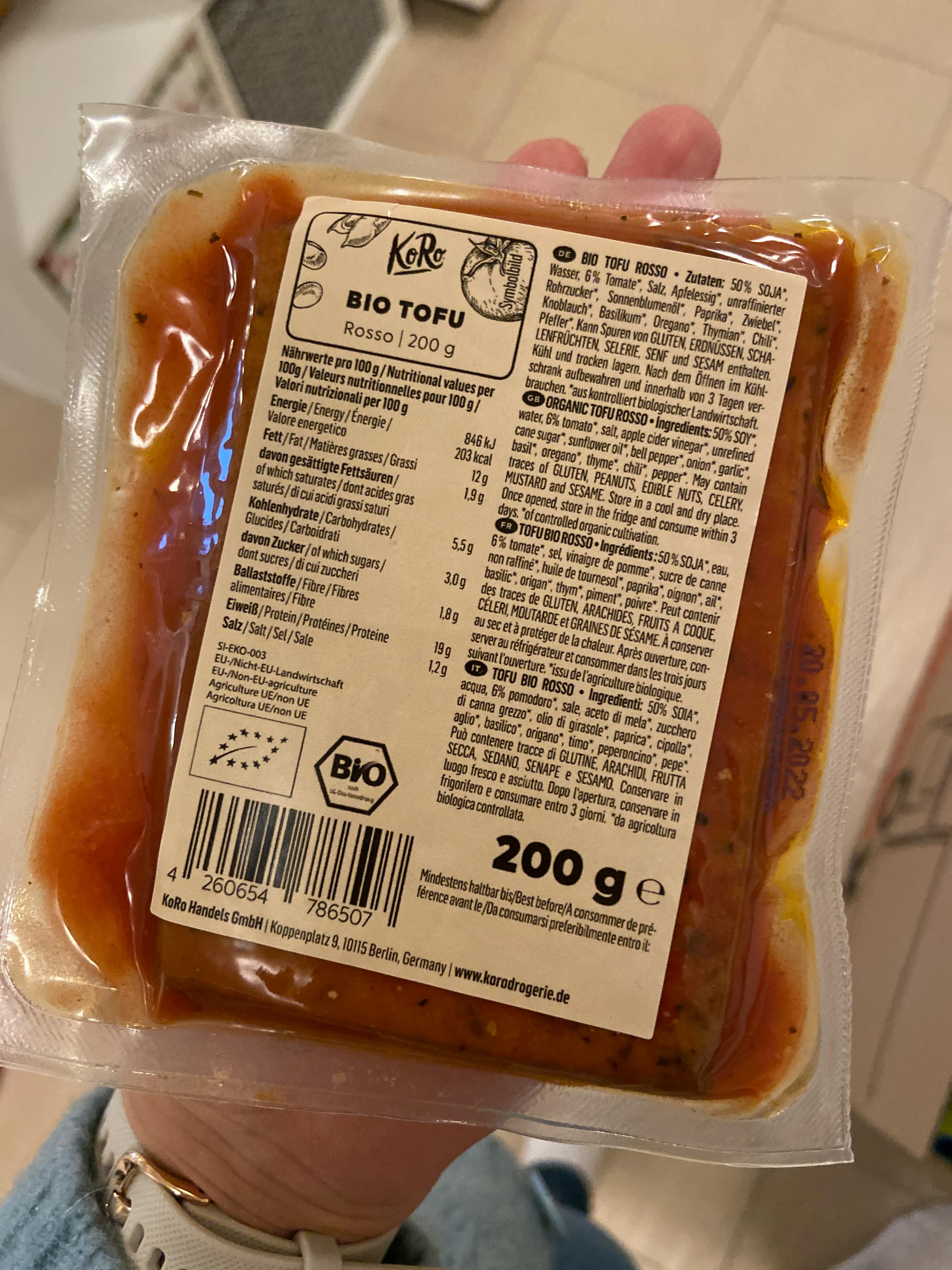 Eine Person hält eine Tüte Bio-Tofu in der Hand