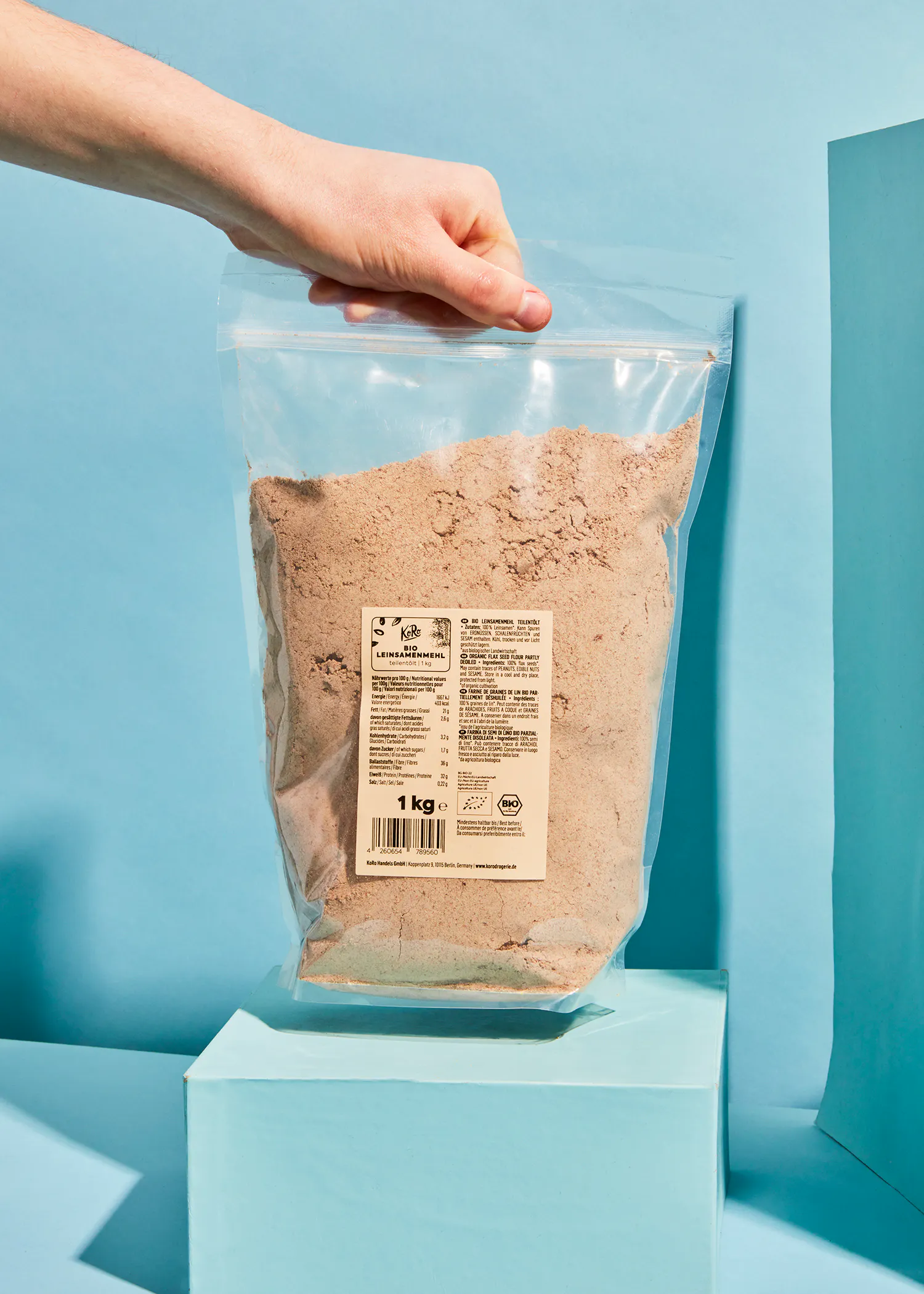 eine Person hält eine Plastiktüte mit einem Gewicht von 1 kg