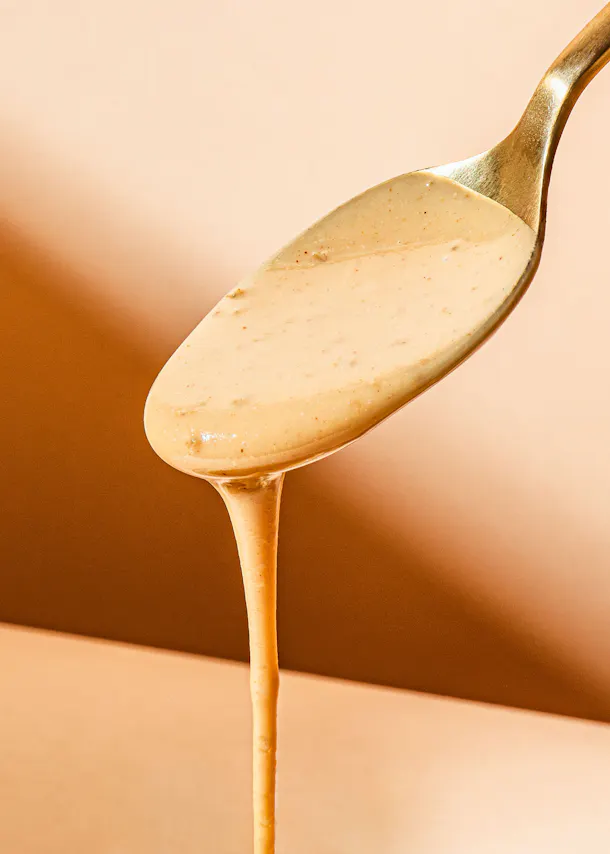 a spoon full of sauce is being poured into a bowl