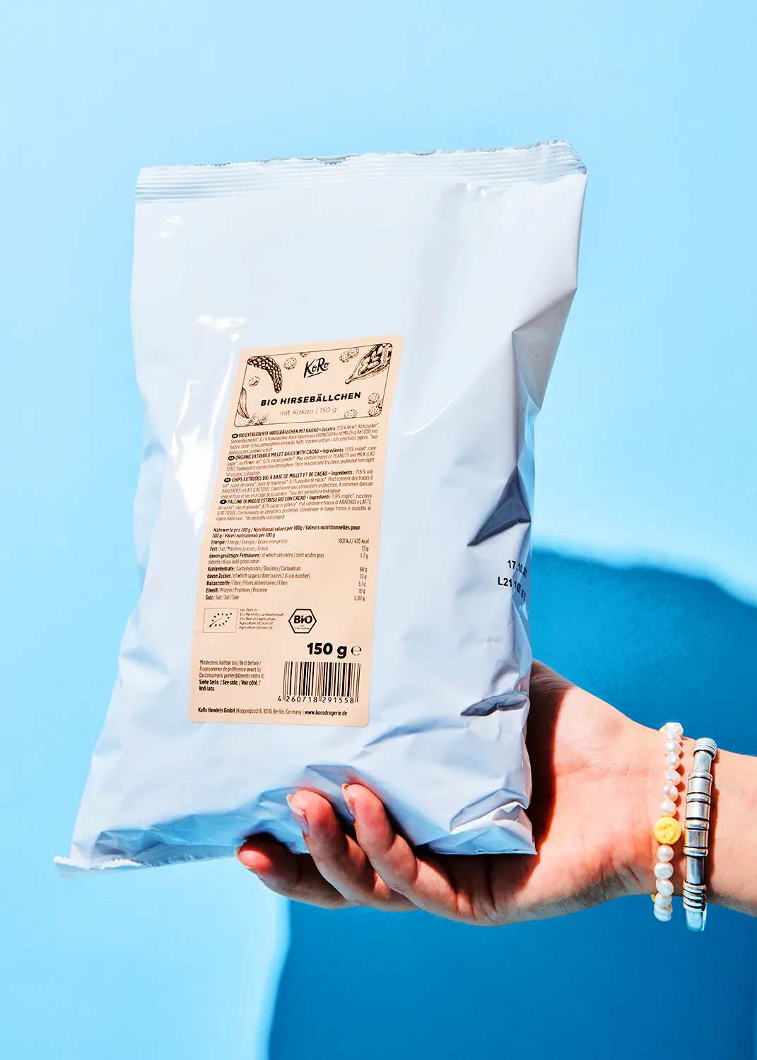 une personne tient un sac de chips bio à la main