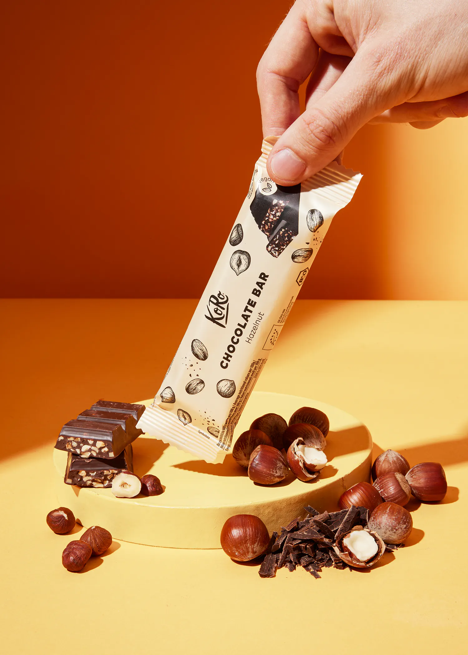 une personne tient une barre de chocolat avec des noisettes