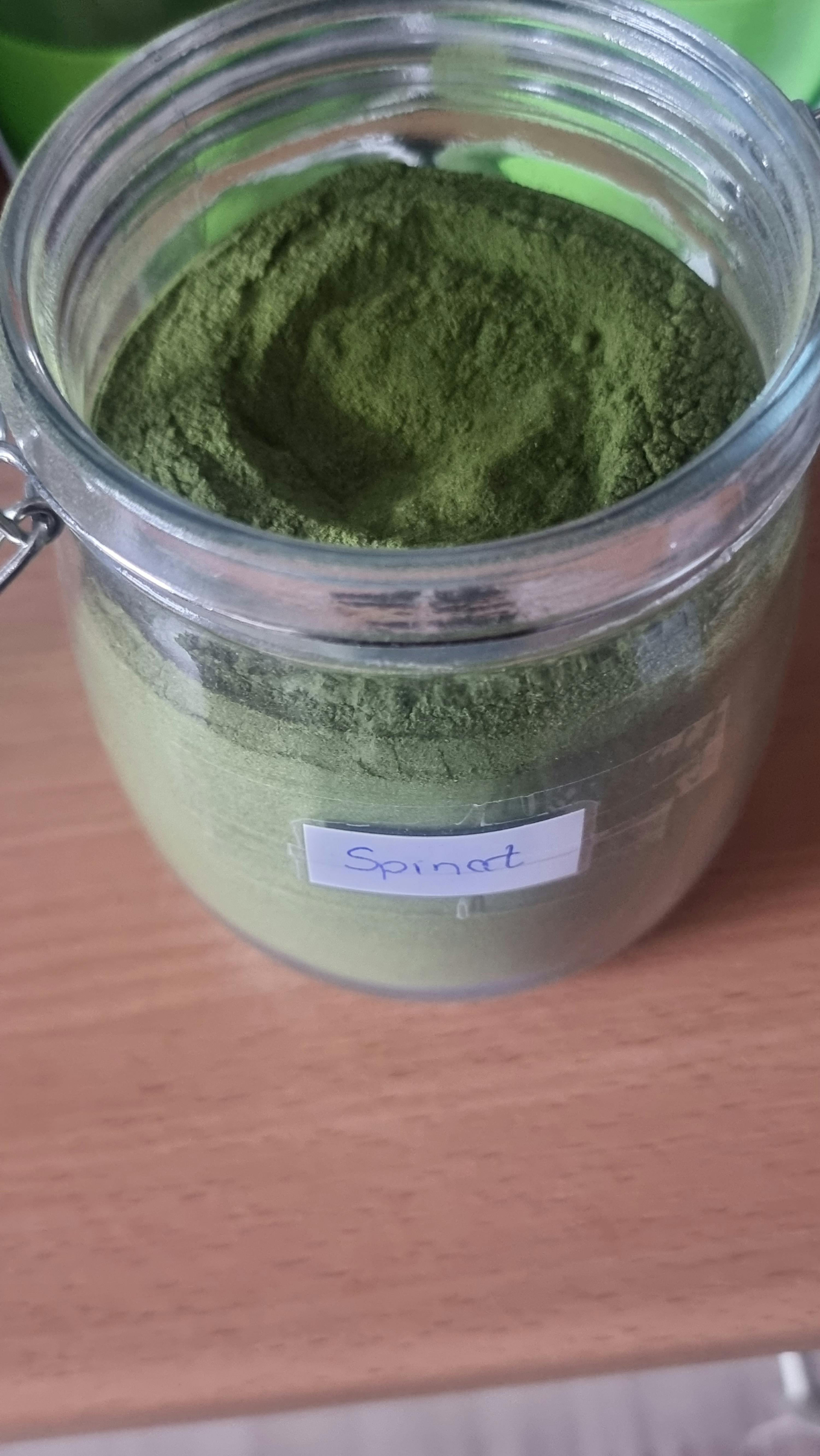 a jar of spinach powder sits on a table