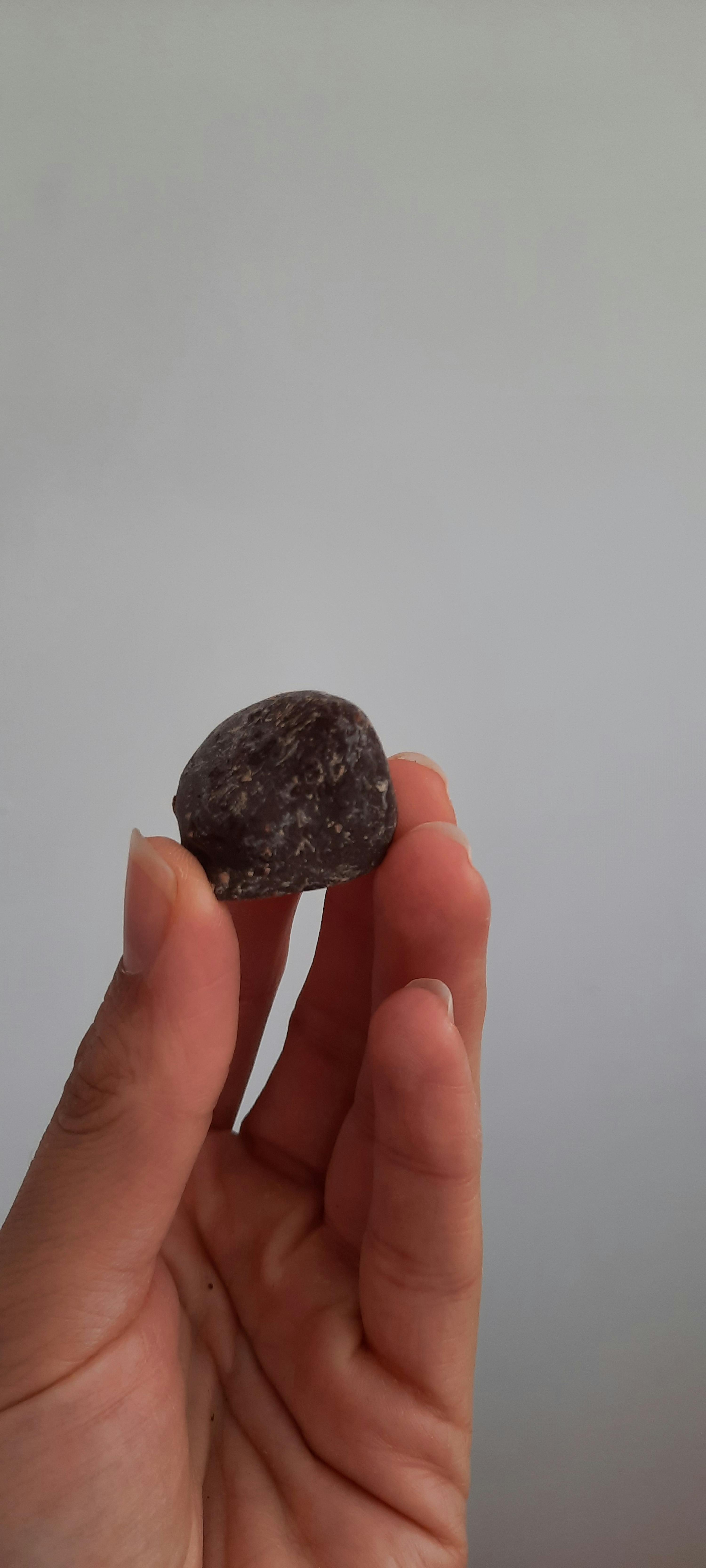 a person holding a small rock in their hand