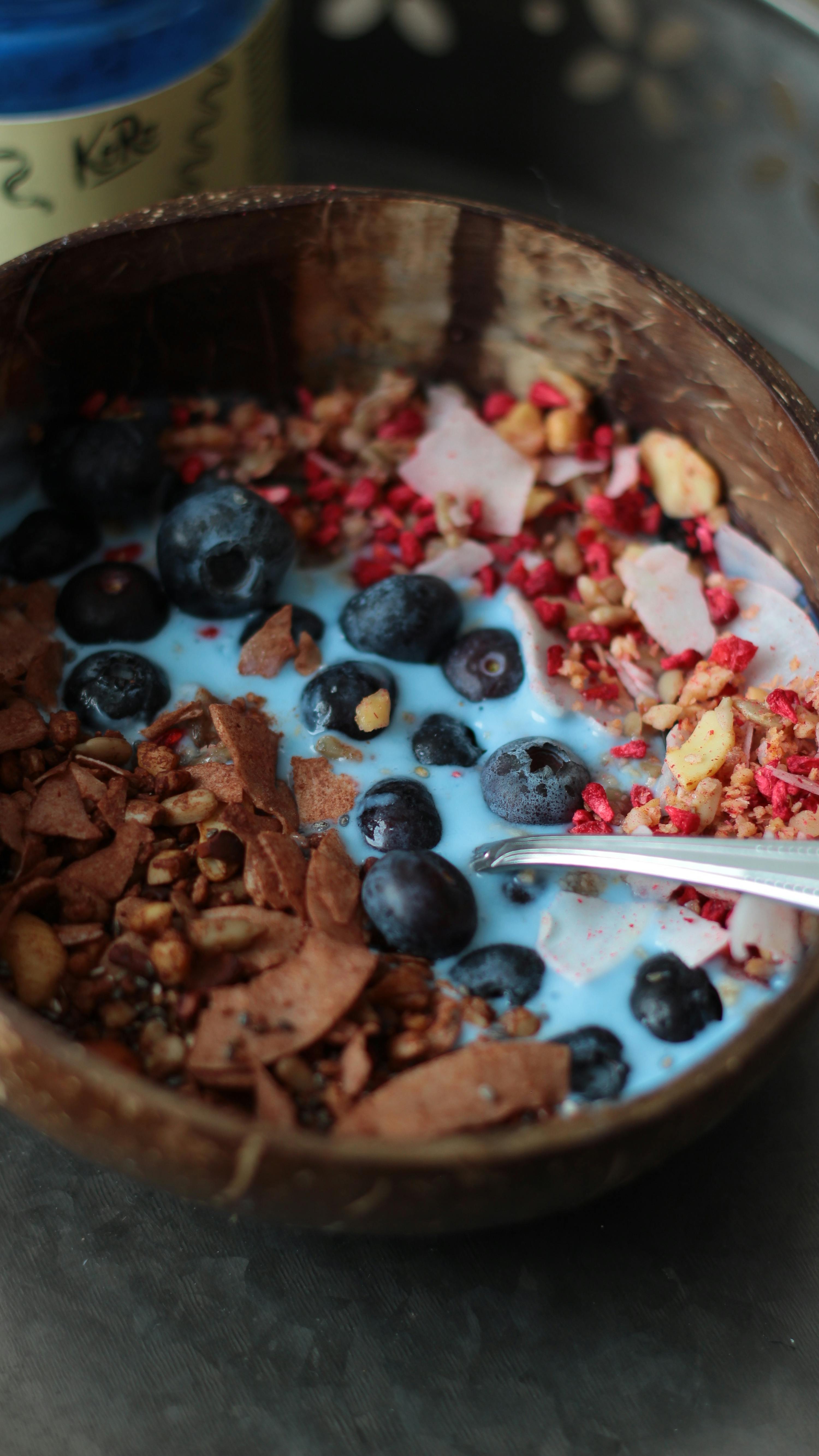 una ciotola di yogurt con mirtilli e granola con una forchetta