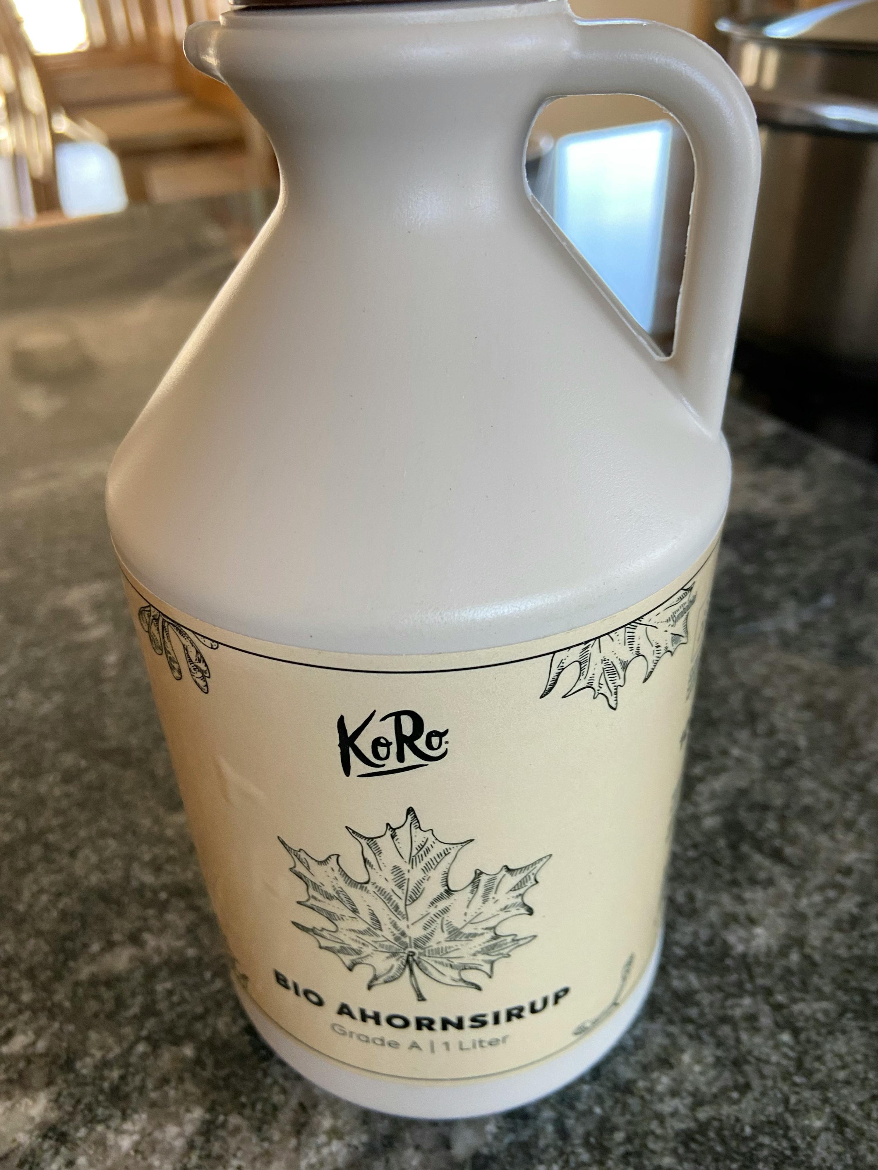 a pitcher of bio maple syrup sits on a counter