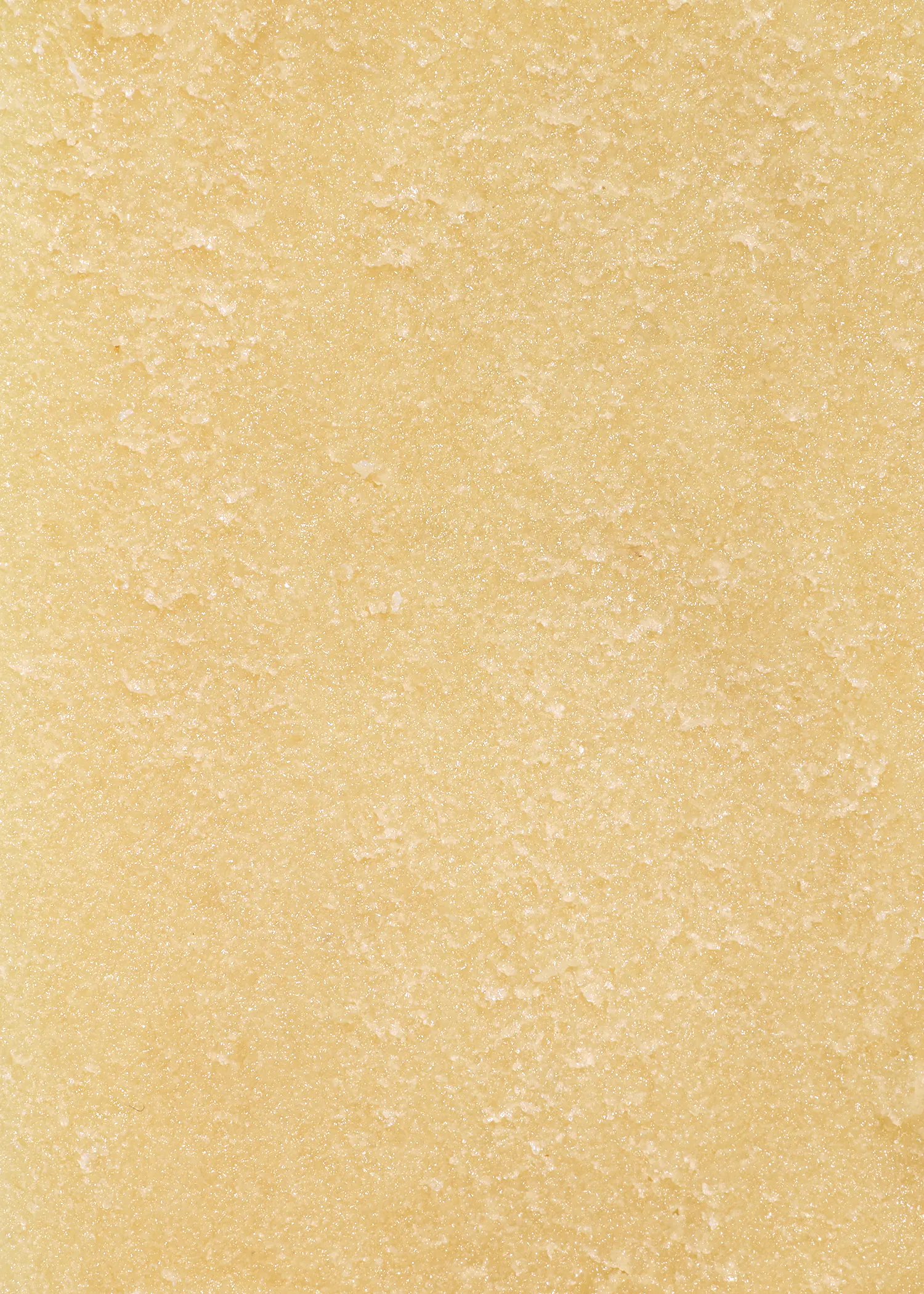 eine nahaufnahme einer hellgelben, körnigen textur mit unregelmäßigen oberflächen.