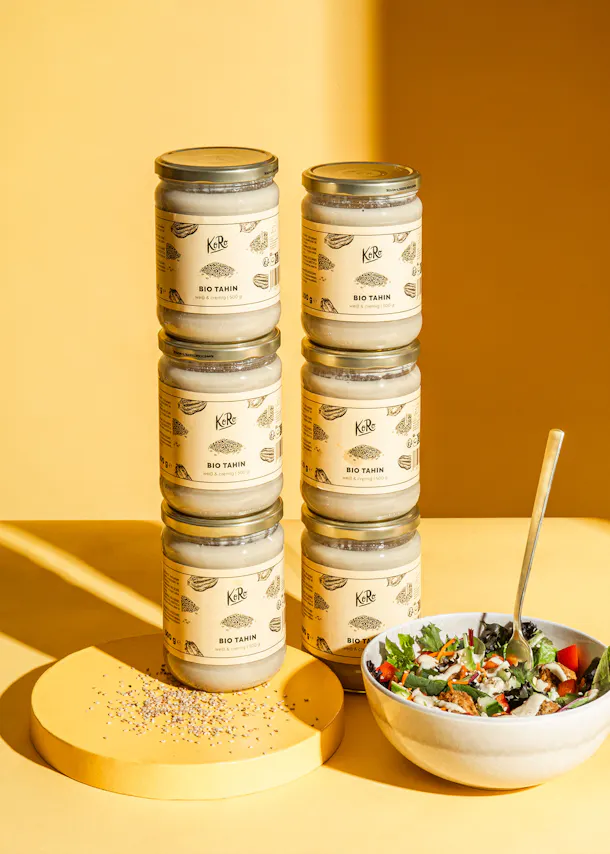 un tas de bocaux empilés les uns sur les autres avec un bol de salade à côté