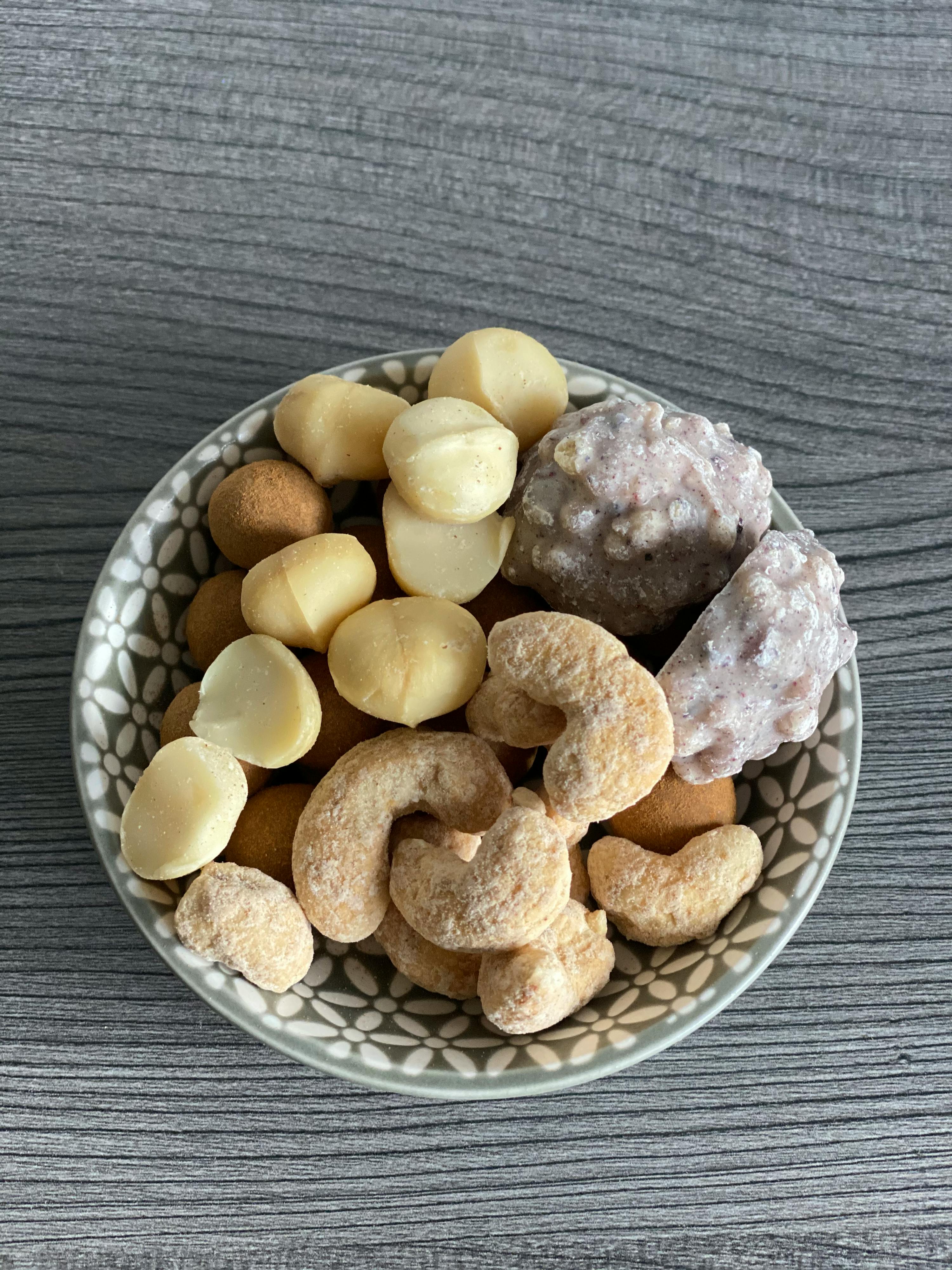 eine Schüssel mit verschiedenen Nüssen auf einem Holztisch