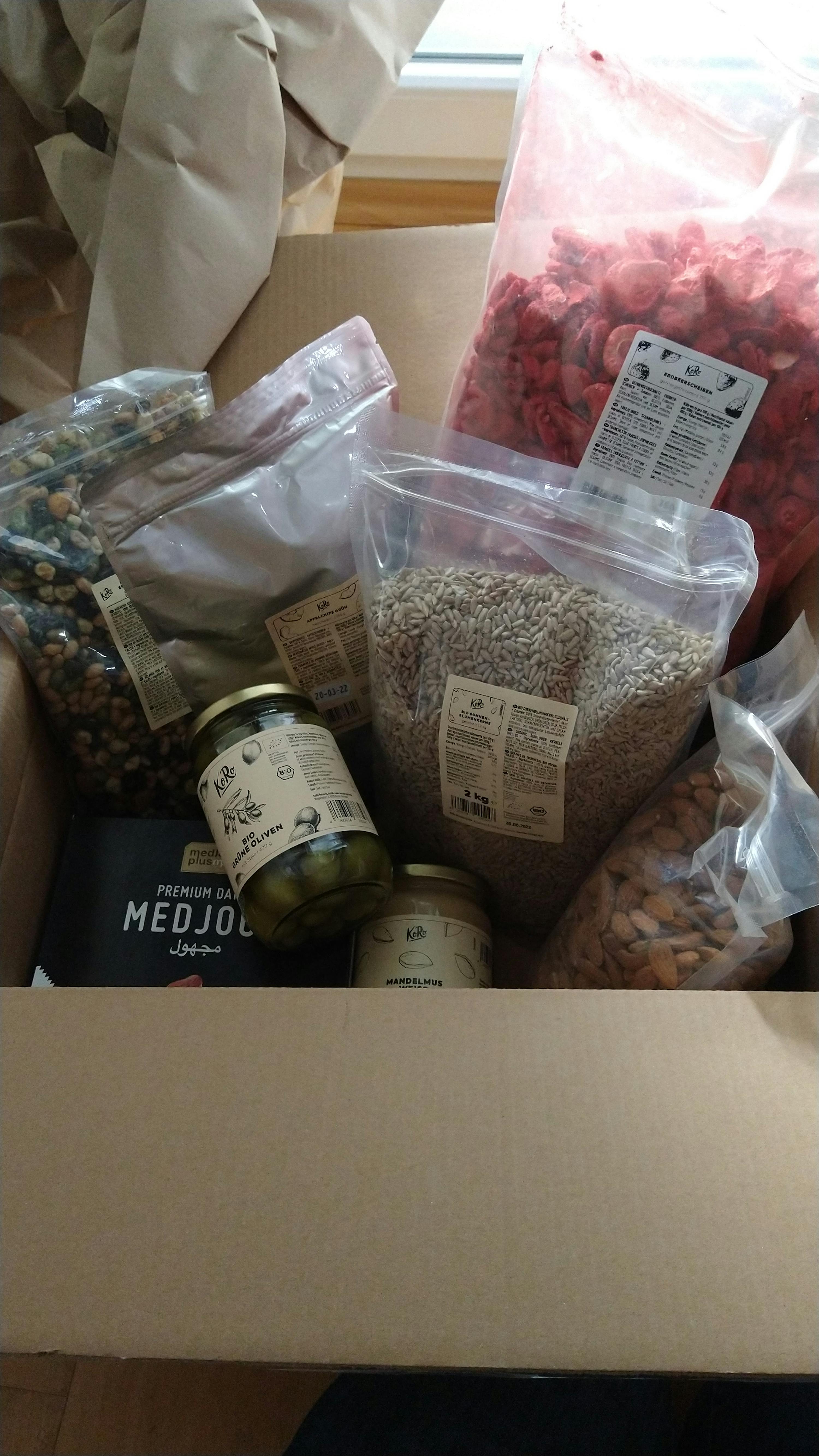 a box filled with nuts and a jar of medjool olives