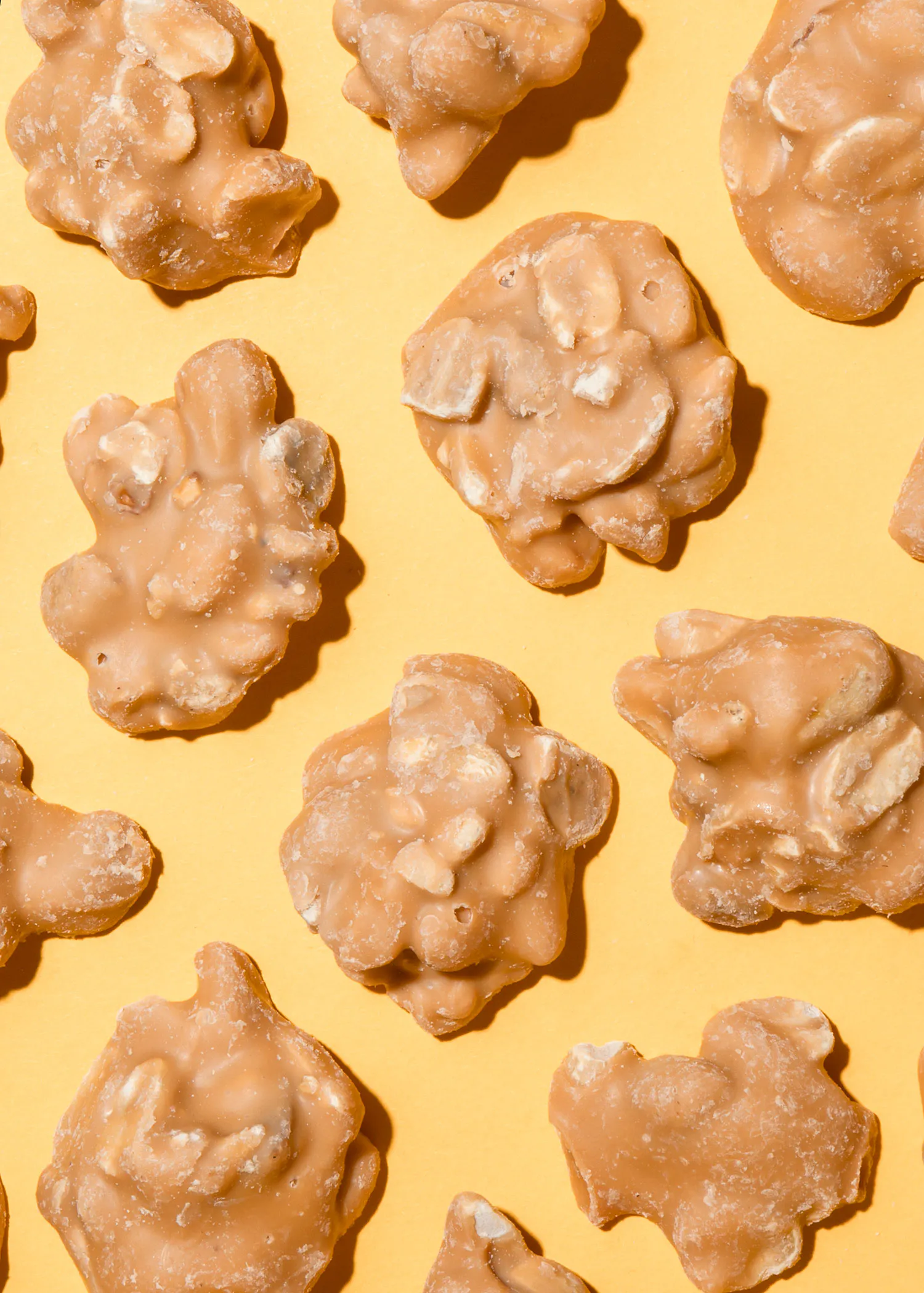 un tas de noix enrobées de caramel sur fond jaune