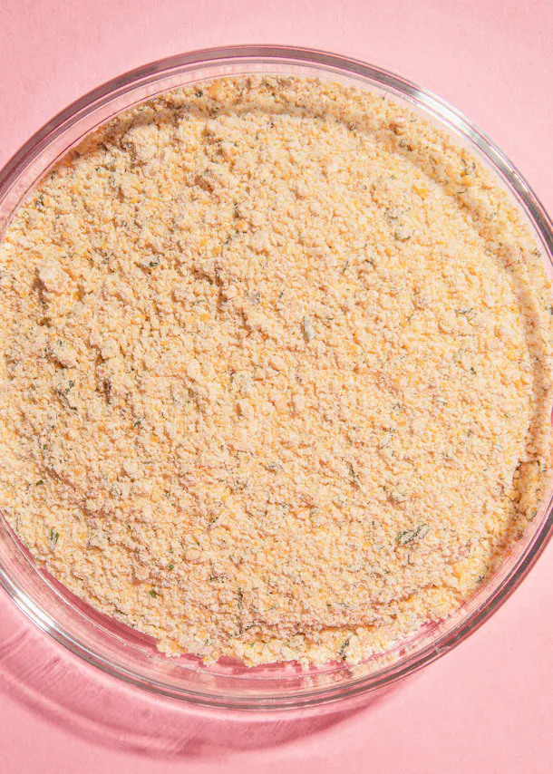 un bol en verre rempli d' un mélange de farine sur une table rose