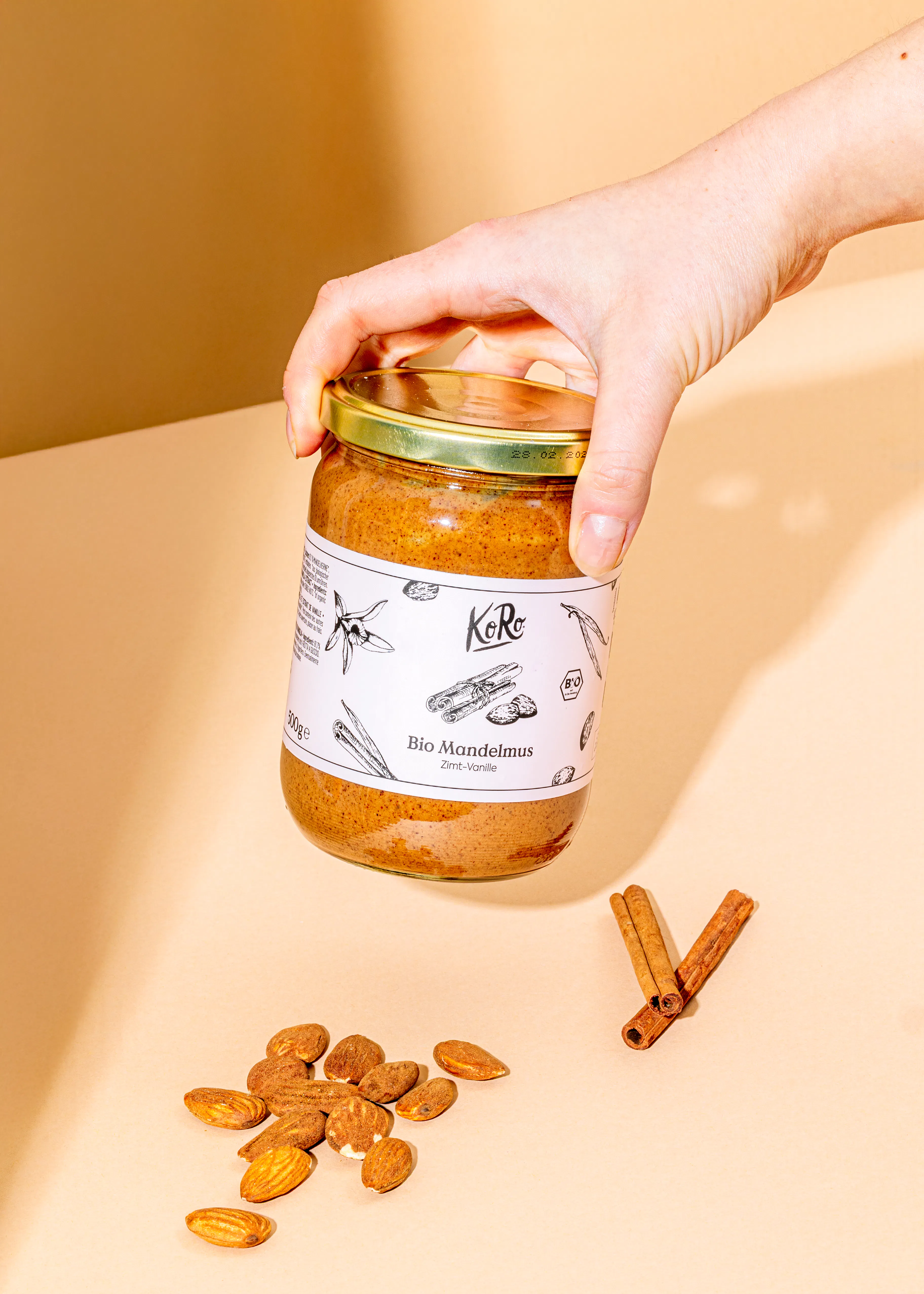 Eine Person hält ein Glas Bio Mandelmus in der Hand