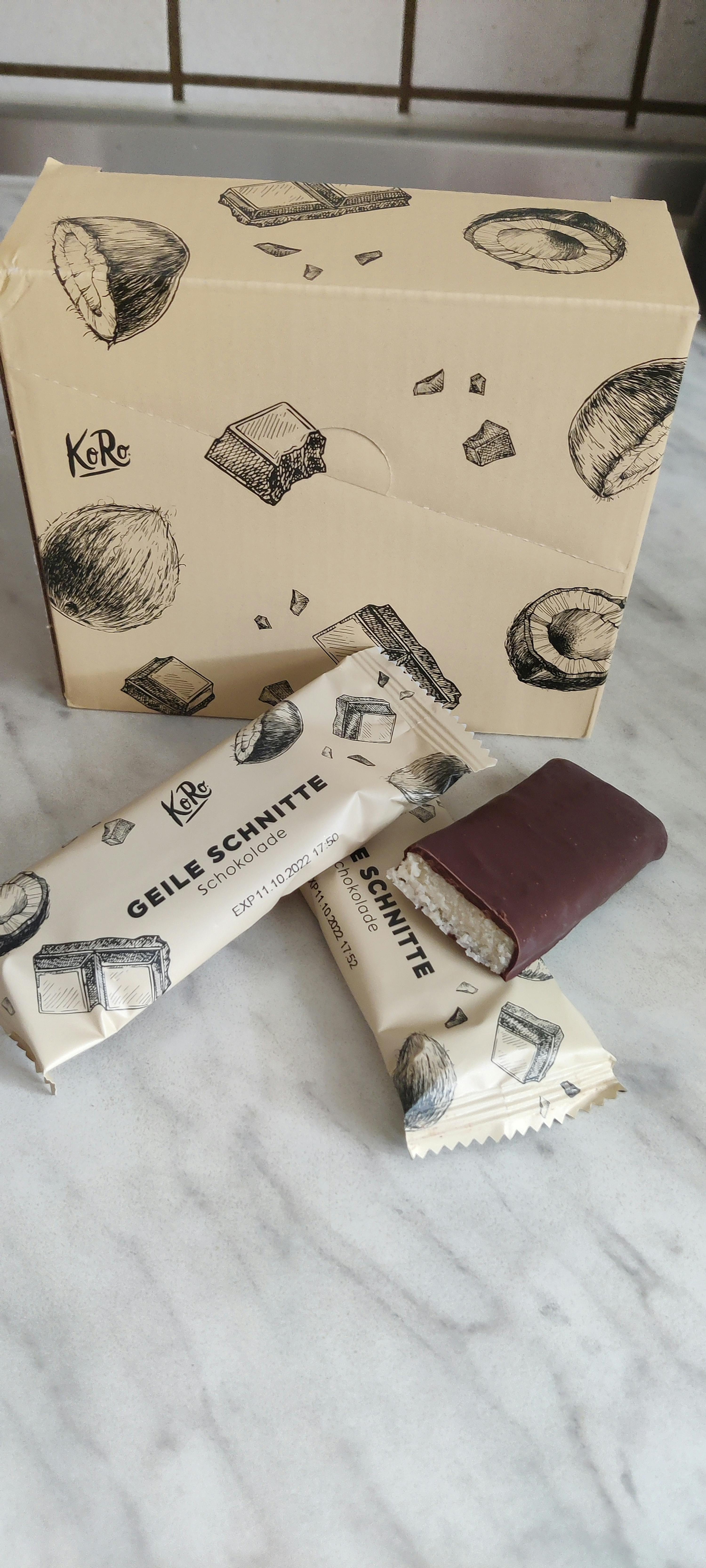 zwei geile schnitte-Schokoladenriegel auf einem Tisch neben einem karton